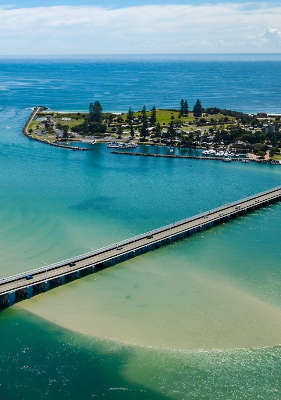 Bridge Over Turquoise Water Leading to Island With Boats — Mid North Coast Drafting & Construction in Forster, NSW