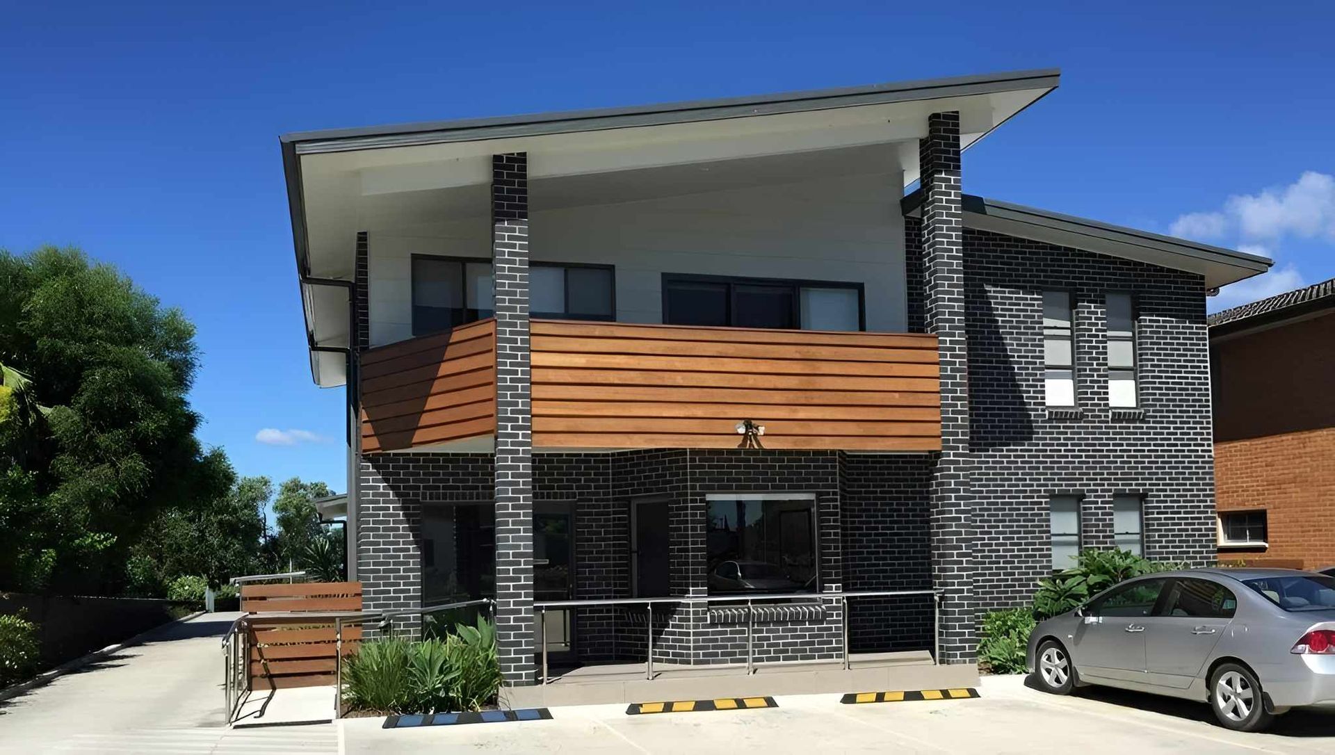 Modern two-story building with black and wood accents — Mid North Coast Drafting & Construction in Taree, NSW