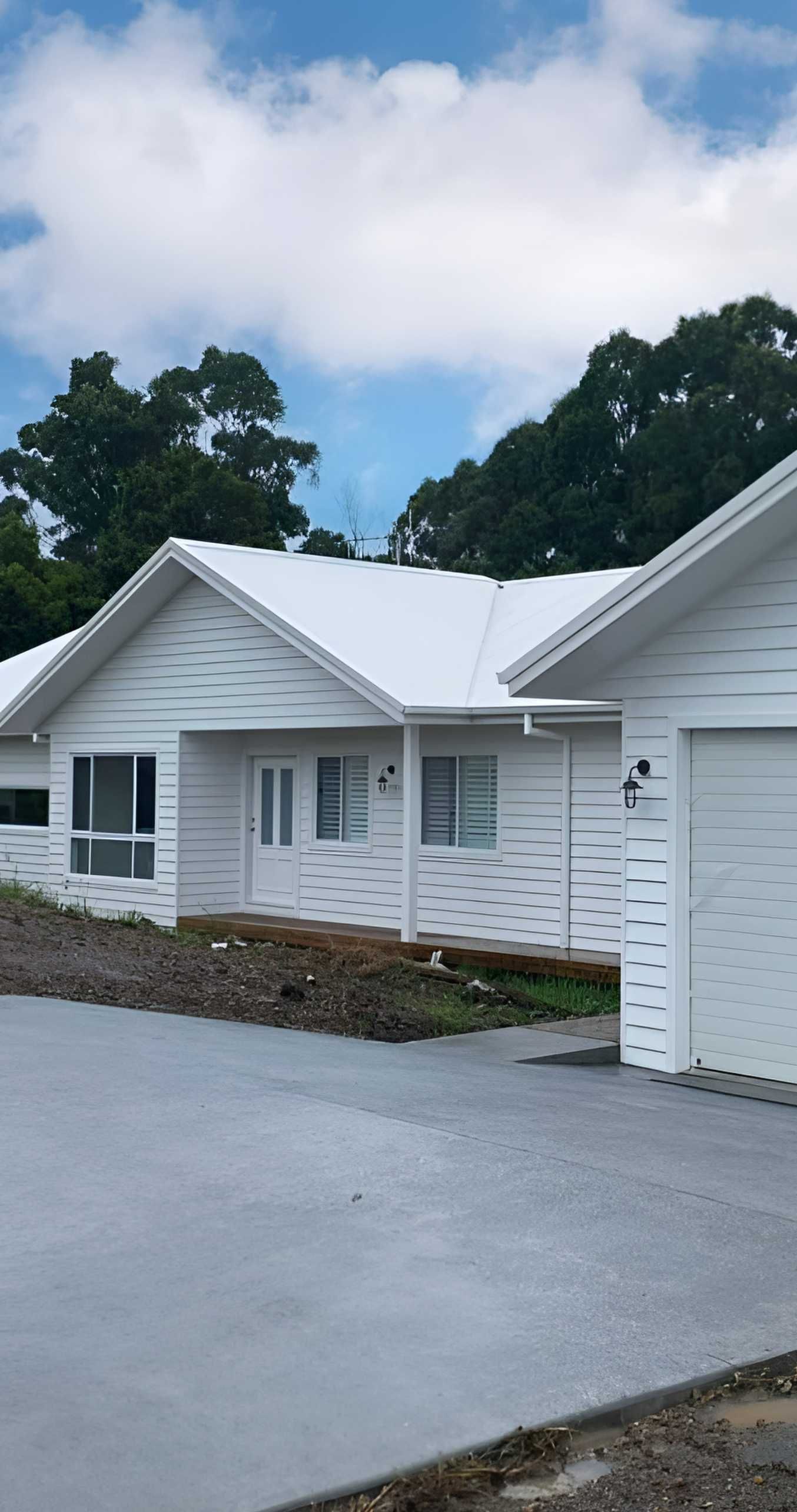 White Houses With Light Gray Driveways and Green Tree Backdrop — Mid North Coast Drafting & Construction in Harrington, NSW