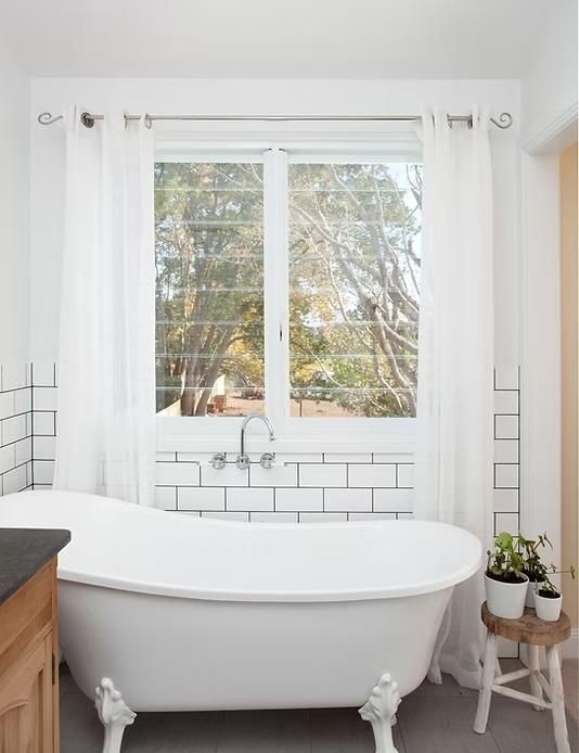 Clawfoot Bathtub in Bathroom With White Subway Tile and Window — Mid North Coast Drafting & Construction in Taree, NSW