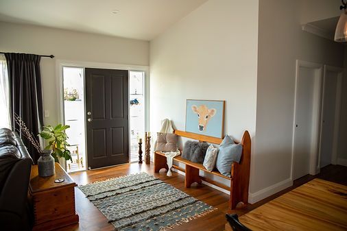 Entryway With Brown Door, Wooden Bench, and Giraffe Painting — Mid North Coast Drafting & Construction in Taree, NSW