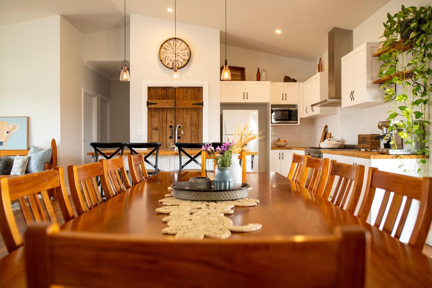 Wooden Dining Table Set With Kitchen View and Plants — Mid North Coast Drafting & Construction in Taree, NSW