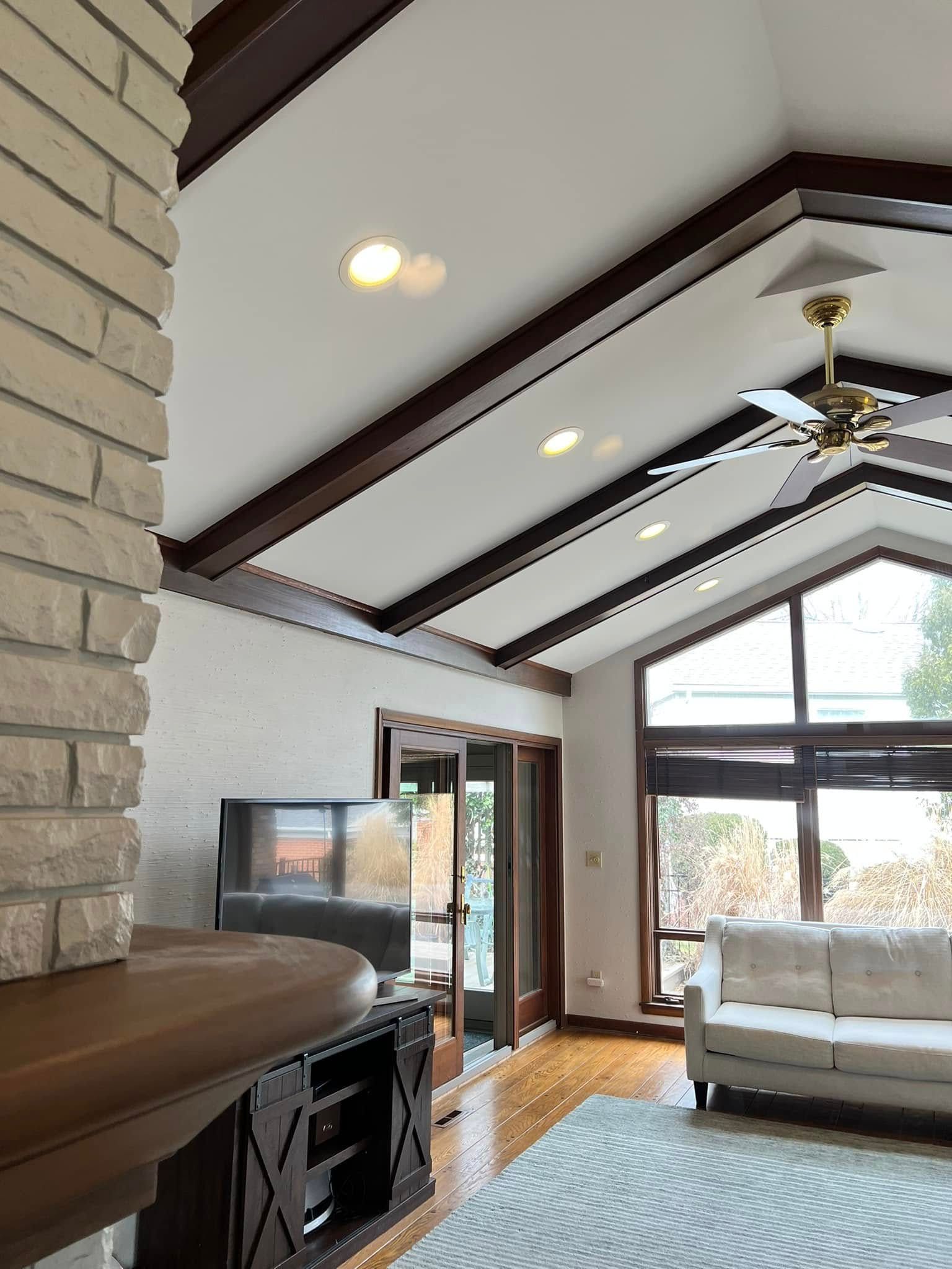 A living room with a vaulted ceiling and a ceiling fan.
