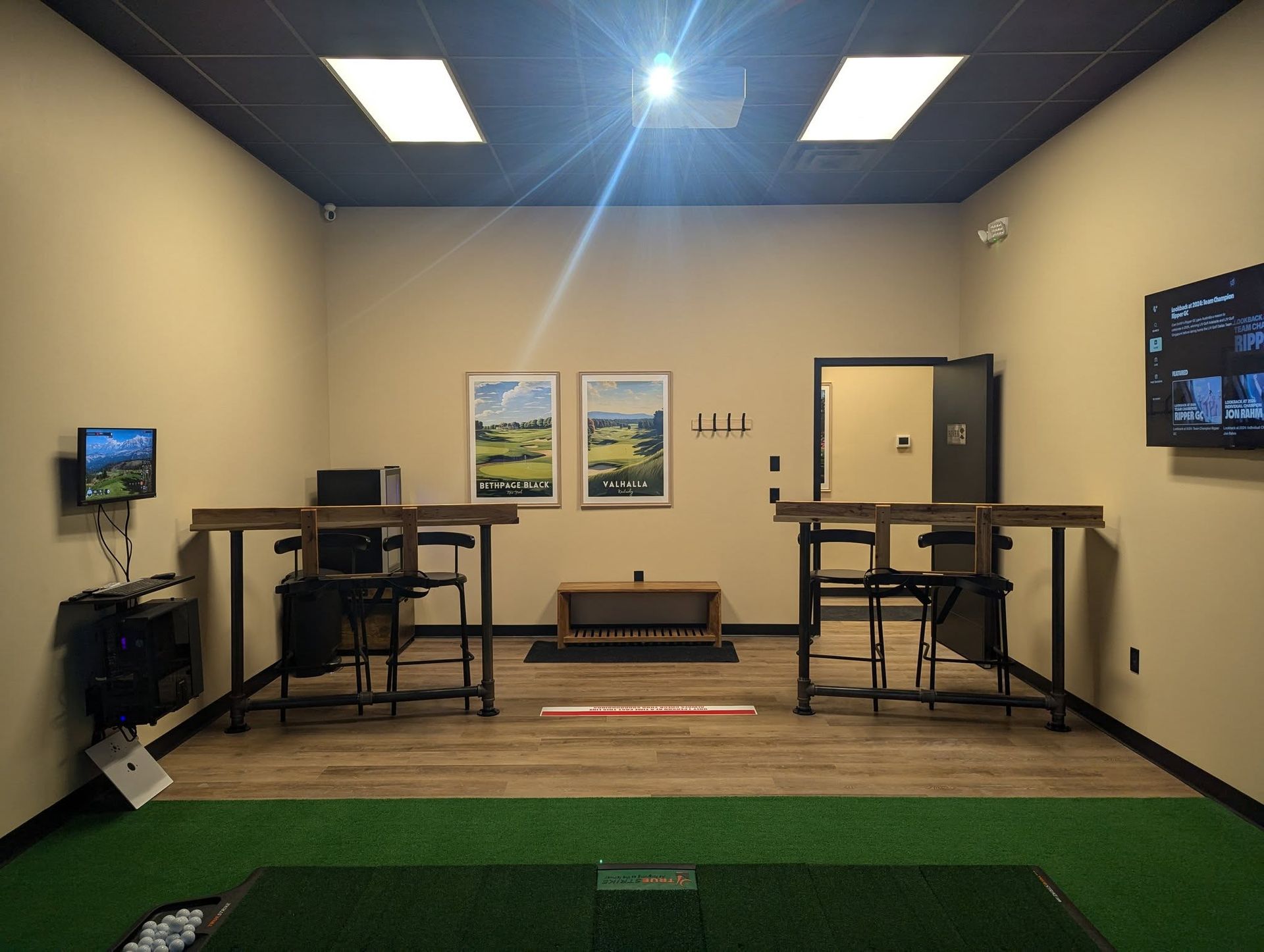 A room with two tables and a television on the wall