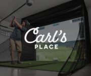 Man swinging golf club in a golf simulator at Carl's Place.