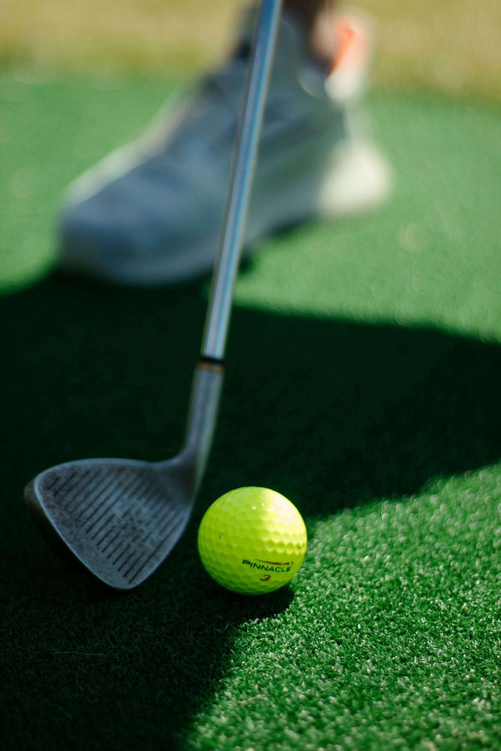 A person is hitting a golf ball with a wedge on a golf course.
