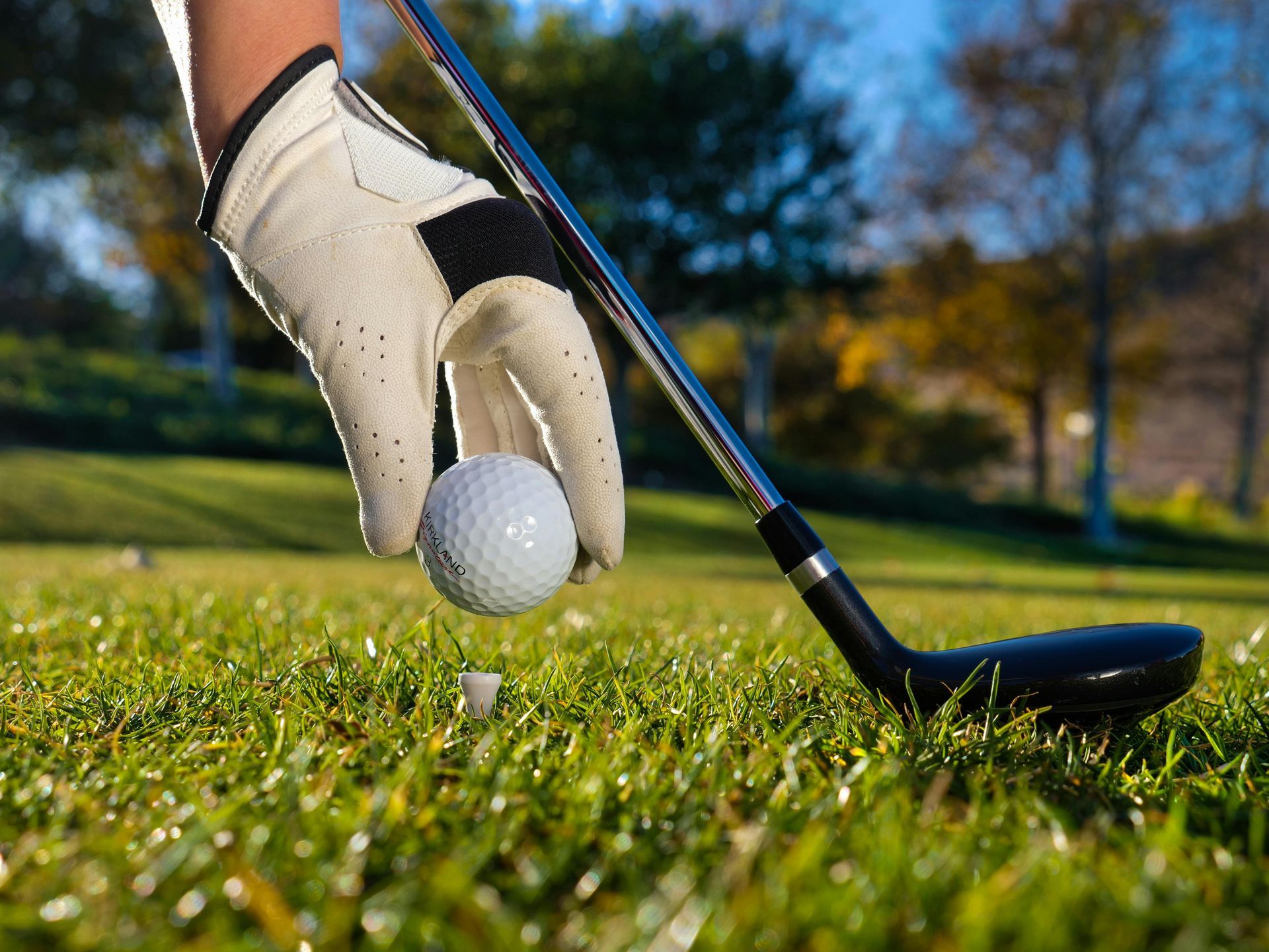 A person is hitting a golf ball with a golf club