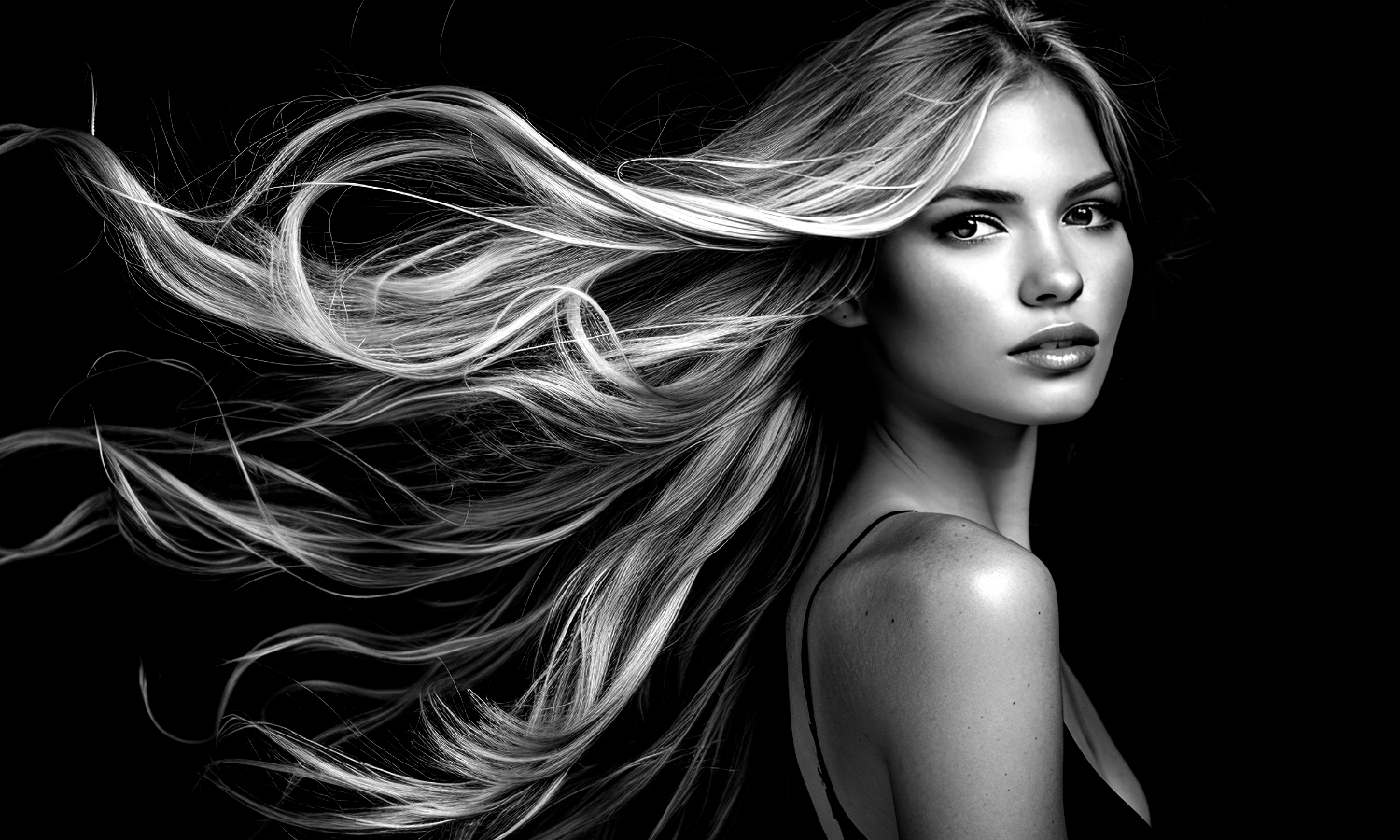 A black and white photo of a woman holding her hair.