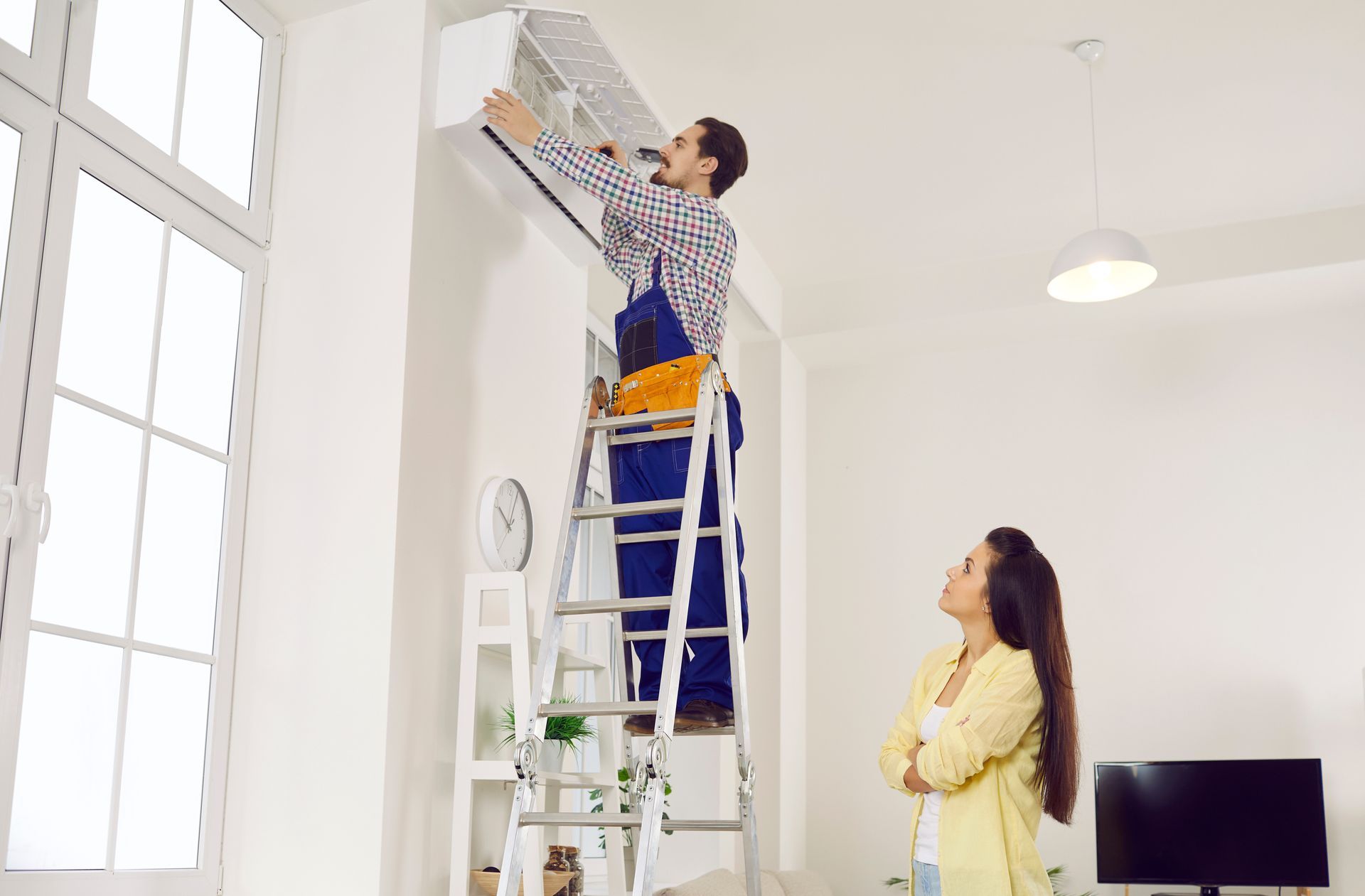 A technician installs an air conditioner in a customer’s home.