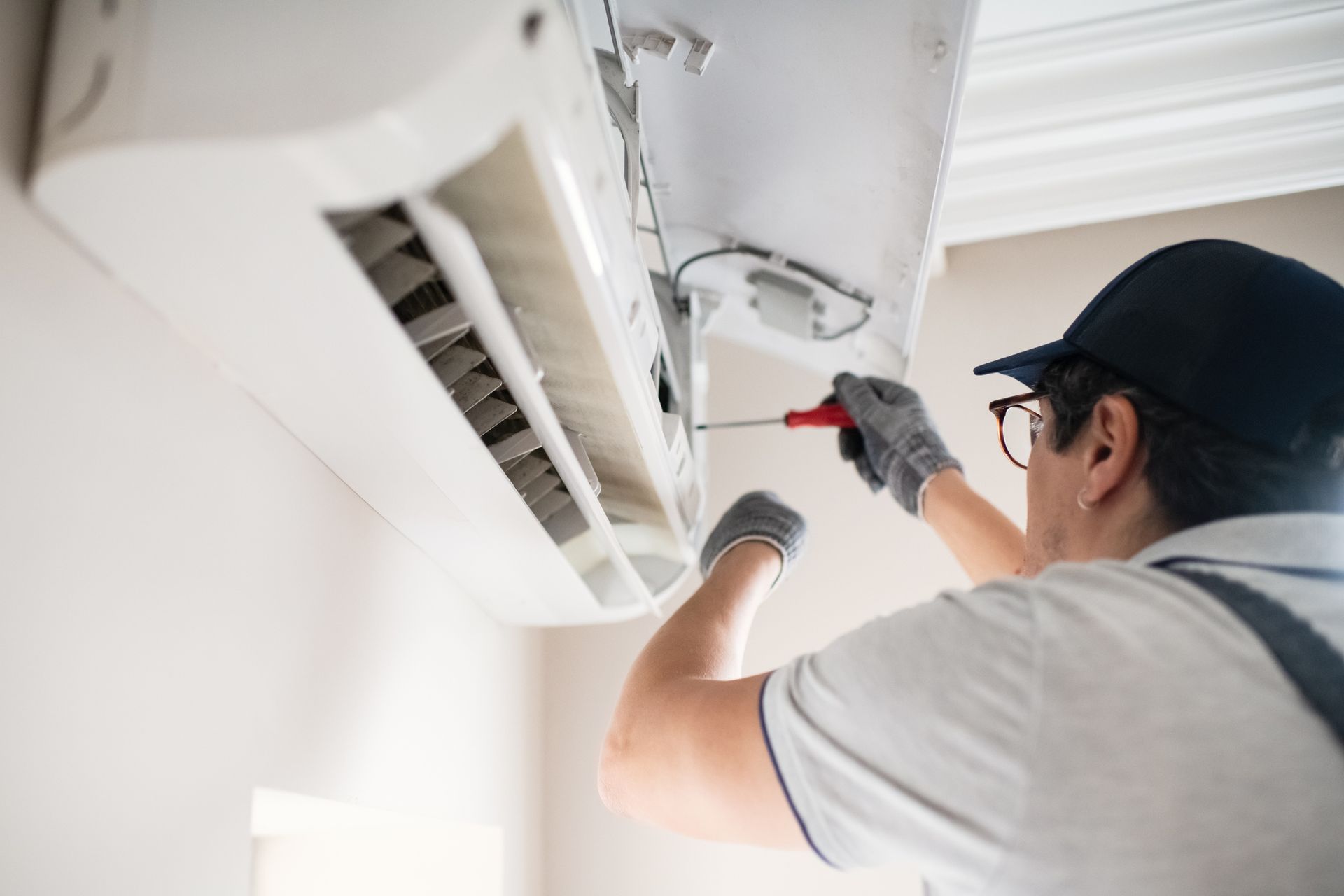 A worker is finishing the installation of an AC unit. A worker is finishing the installation of an AC unit.