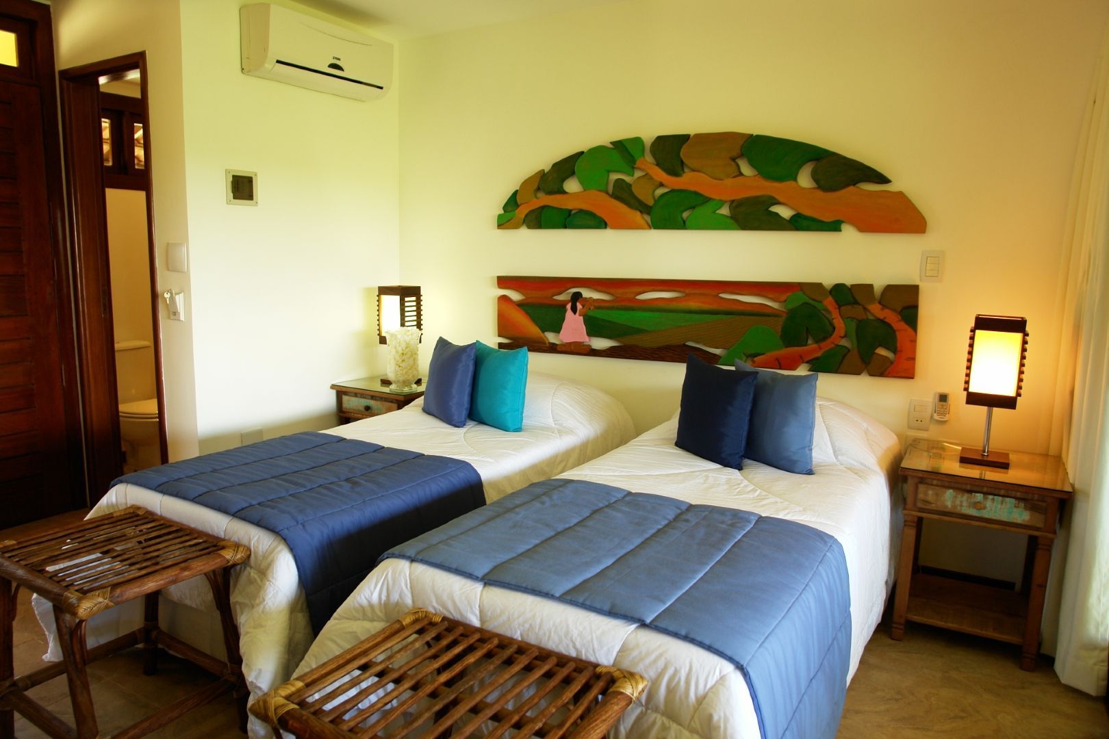 Um quarto de hotel com duas camas e uma pintura na parede
