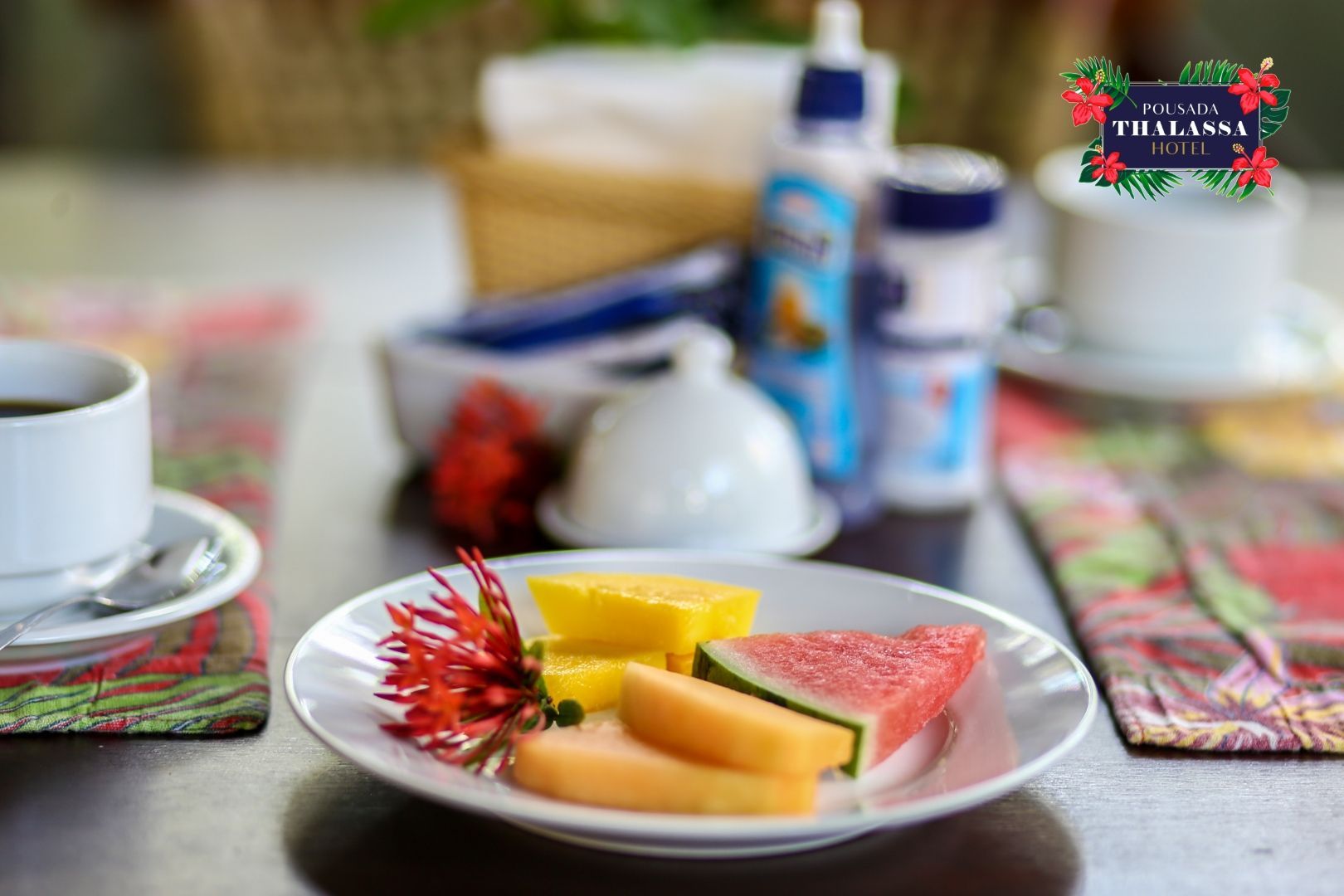 Um prato de frutas e uma xícara de café sobre uma mesa.