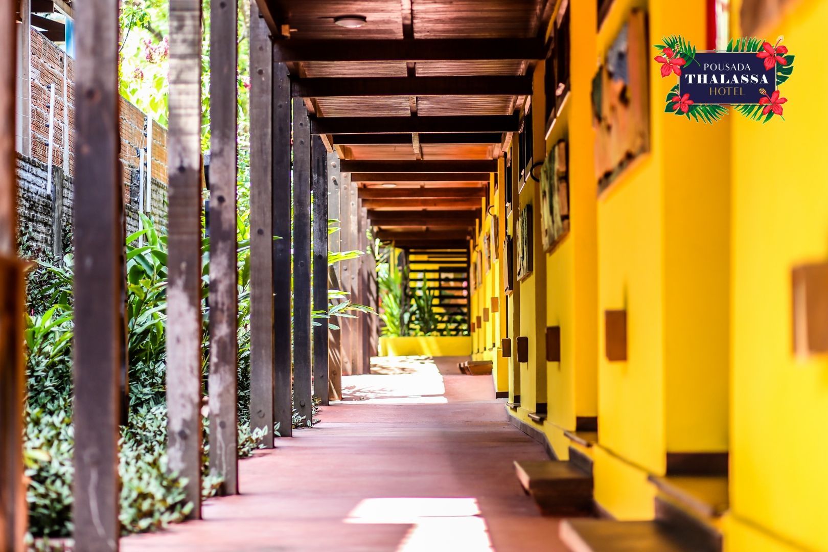 Um longo corredor com paredes amarelas e vigas de madeira