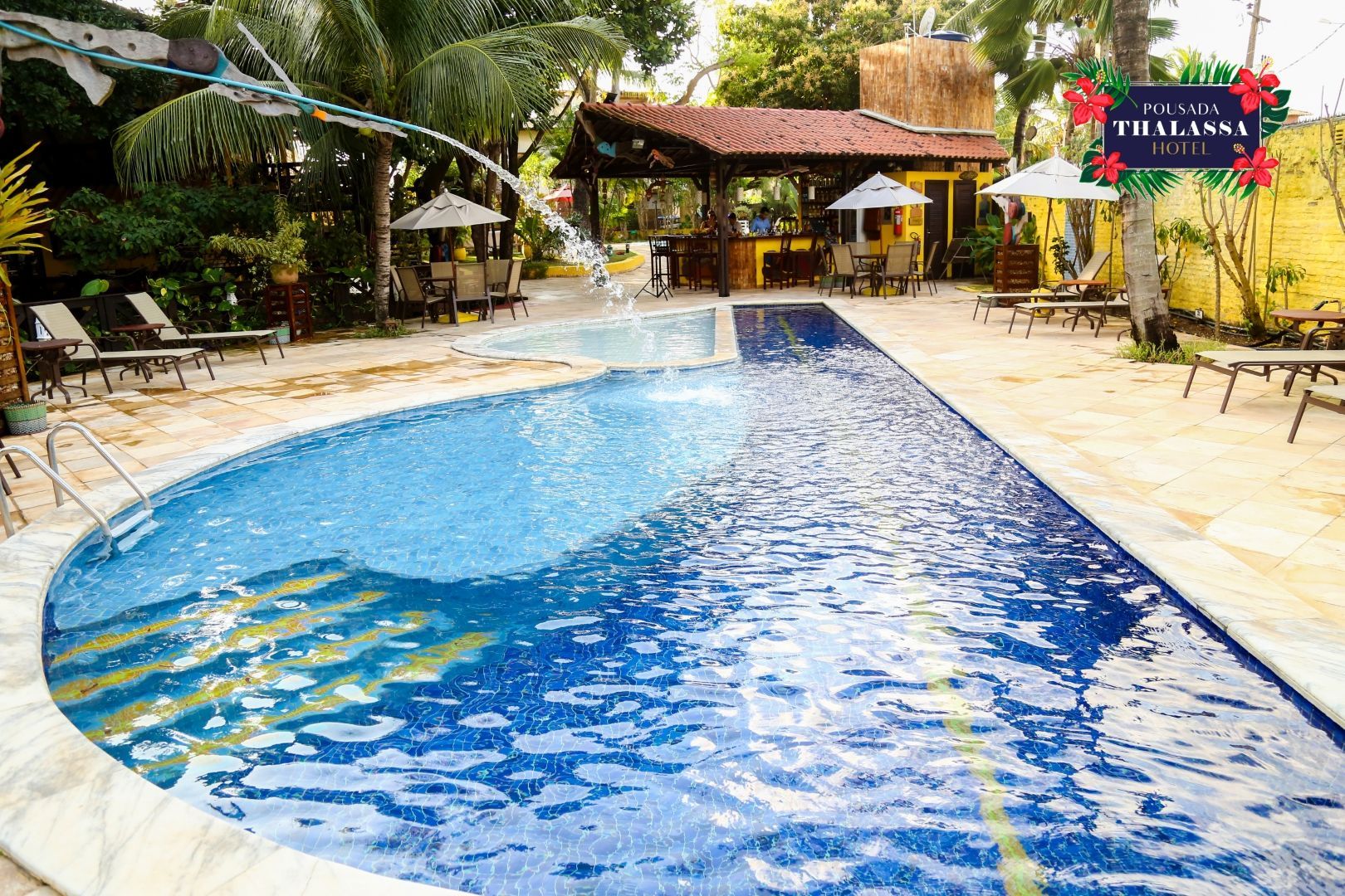 Uma grande piscina com um bar ao fundo