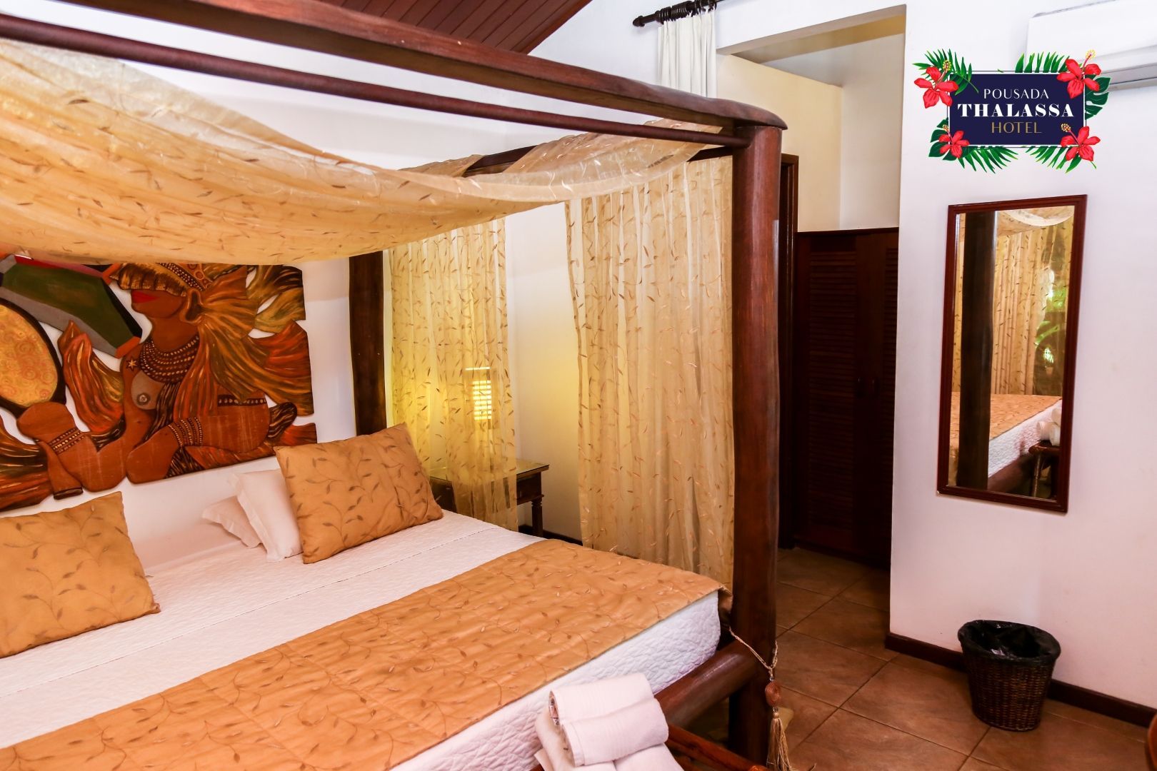 Um quarto com uma cama de dossel e um espelho.