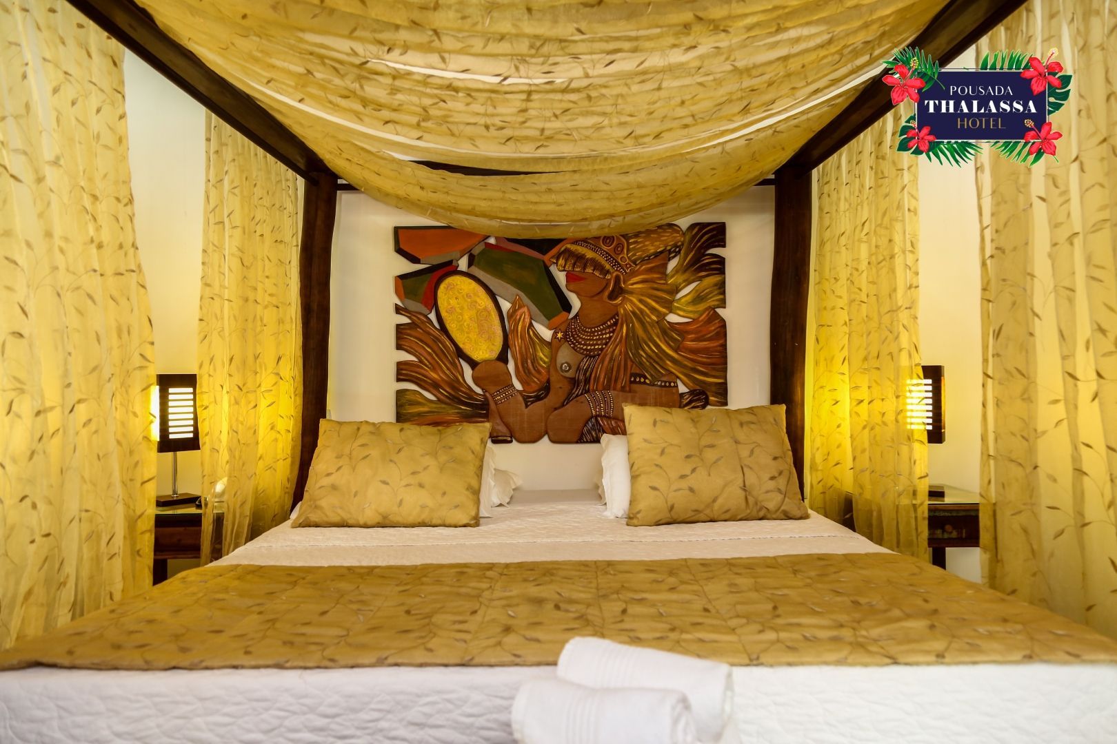 Um quarto de hotel com uma cama de dossel e uma pintura na parede