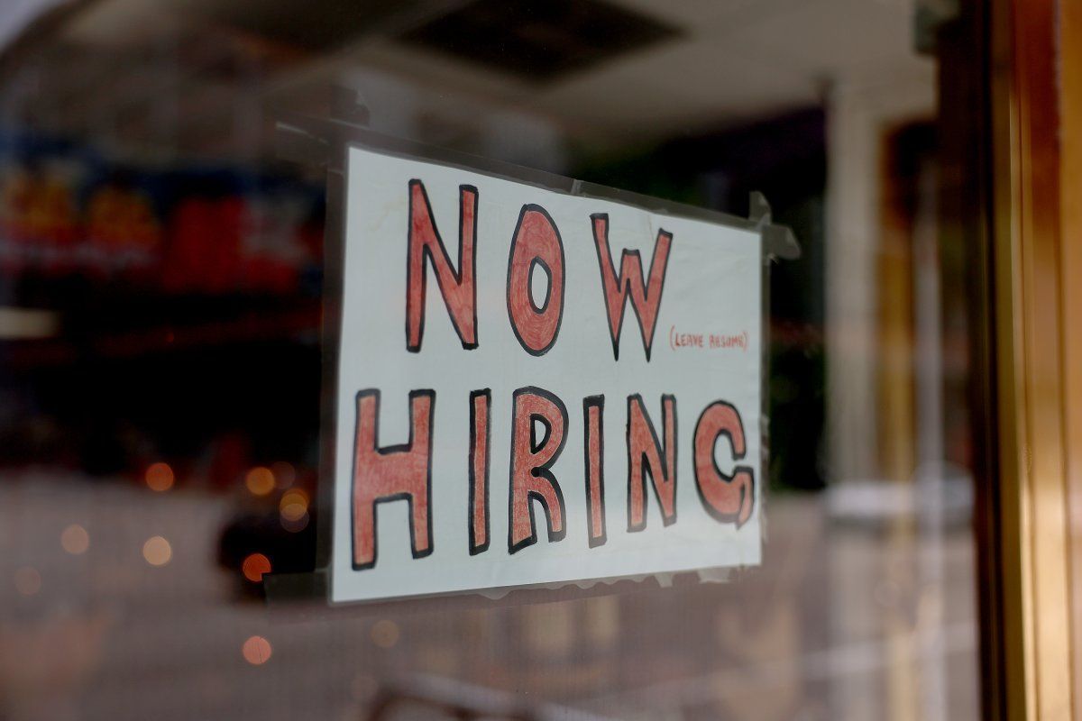 A sign in a window that says `` now hiring ''.