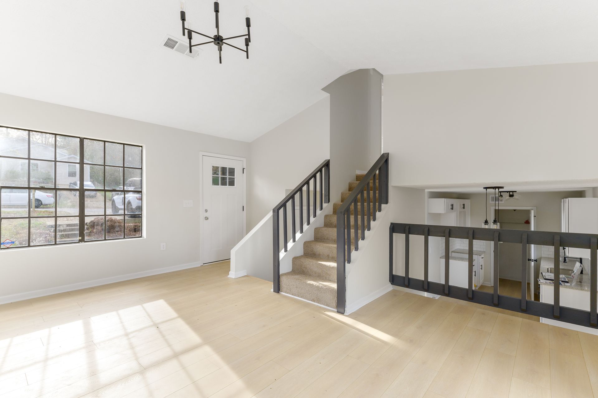 An empty living room with stairs leading up to the second floor.