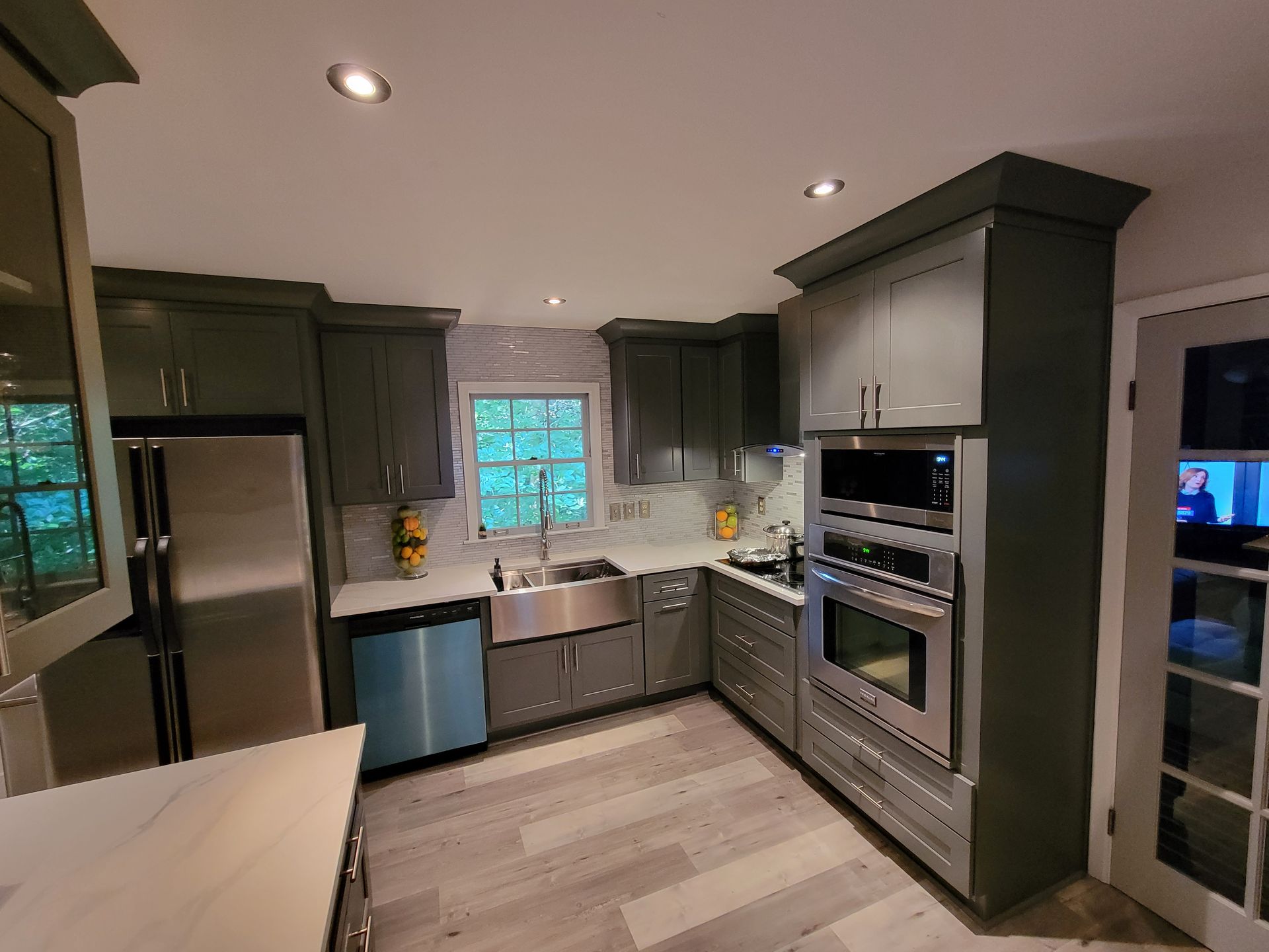 A kitchen with gray cabinets and stainless steel appliances