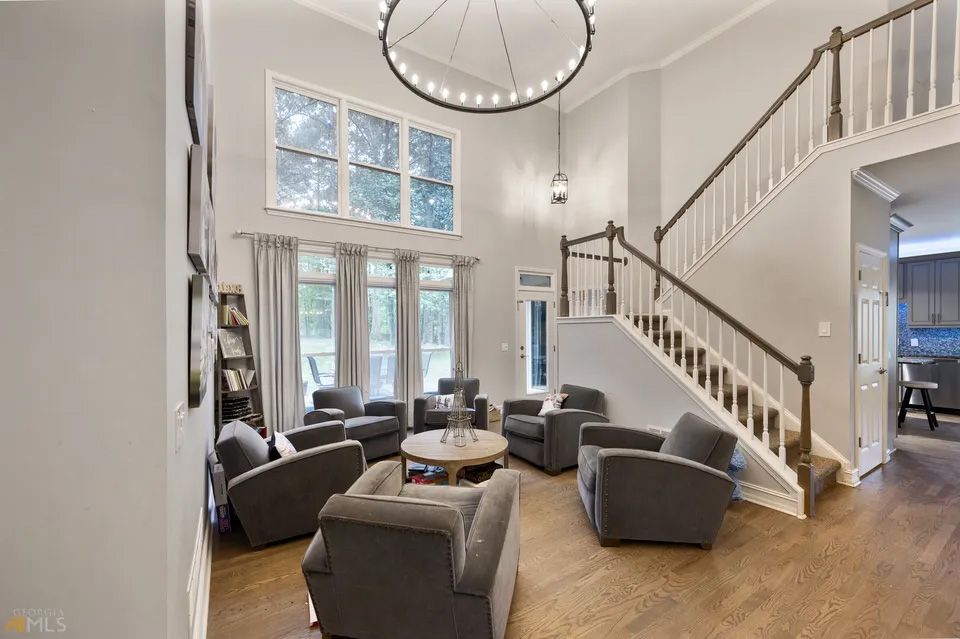A living room filled with furniture and a staircase leading up to the second floor.