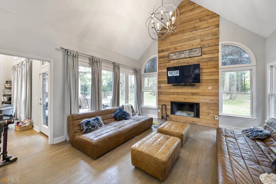 A living room with a couch , ottomans , and a fireplace.