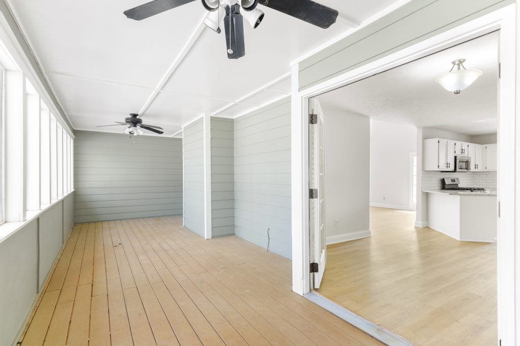 An empty room with hardwood floors and a ceiling fan