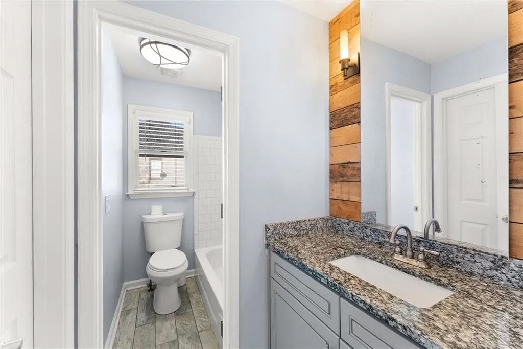 A bathroom with a toilet , sink and mirror