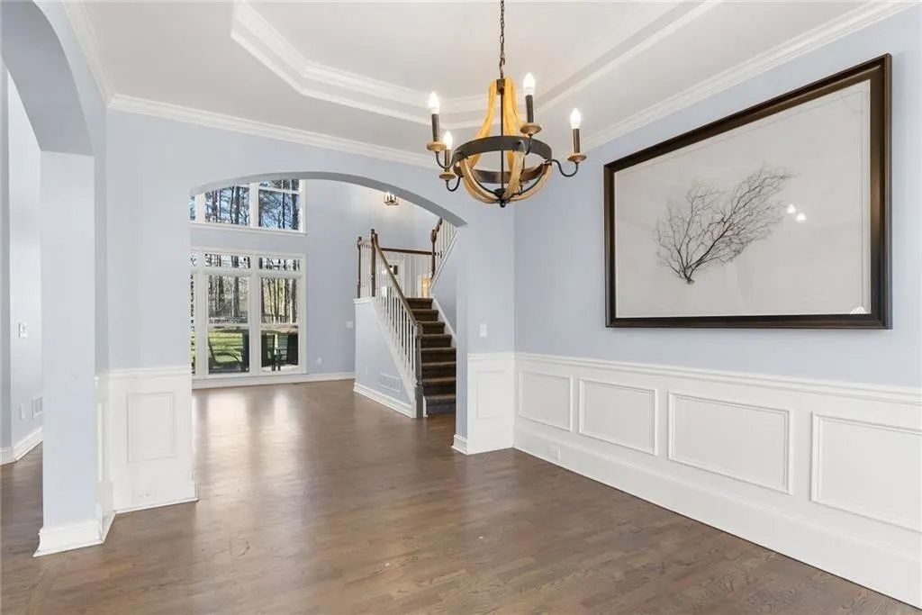 An empty room with a picture on the wall and a chandelier