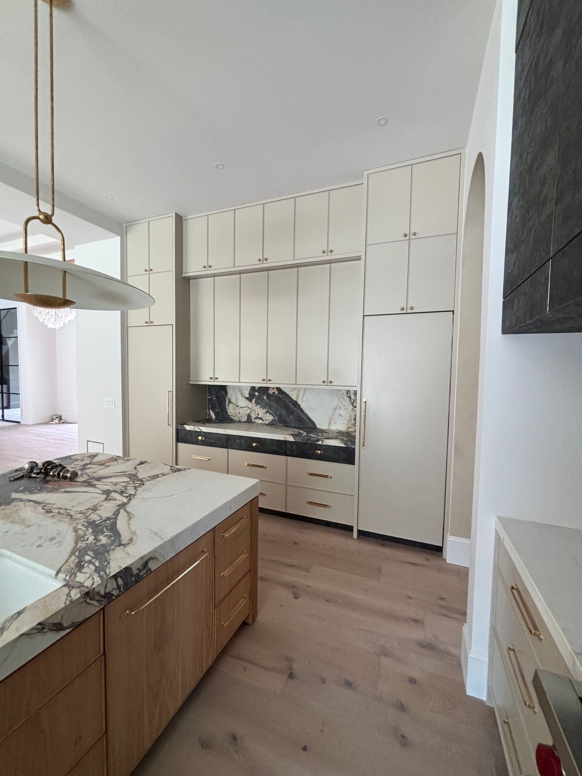 A kitchen with wooden cabinets and marble counter tops
