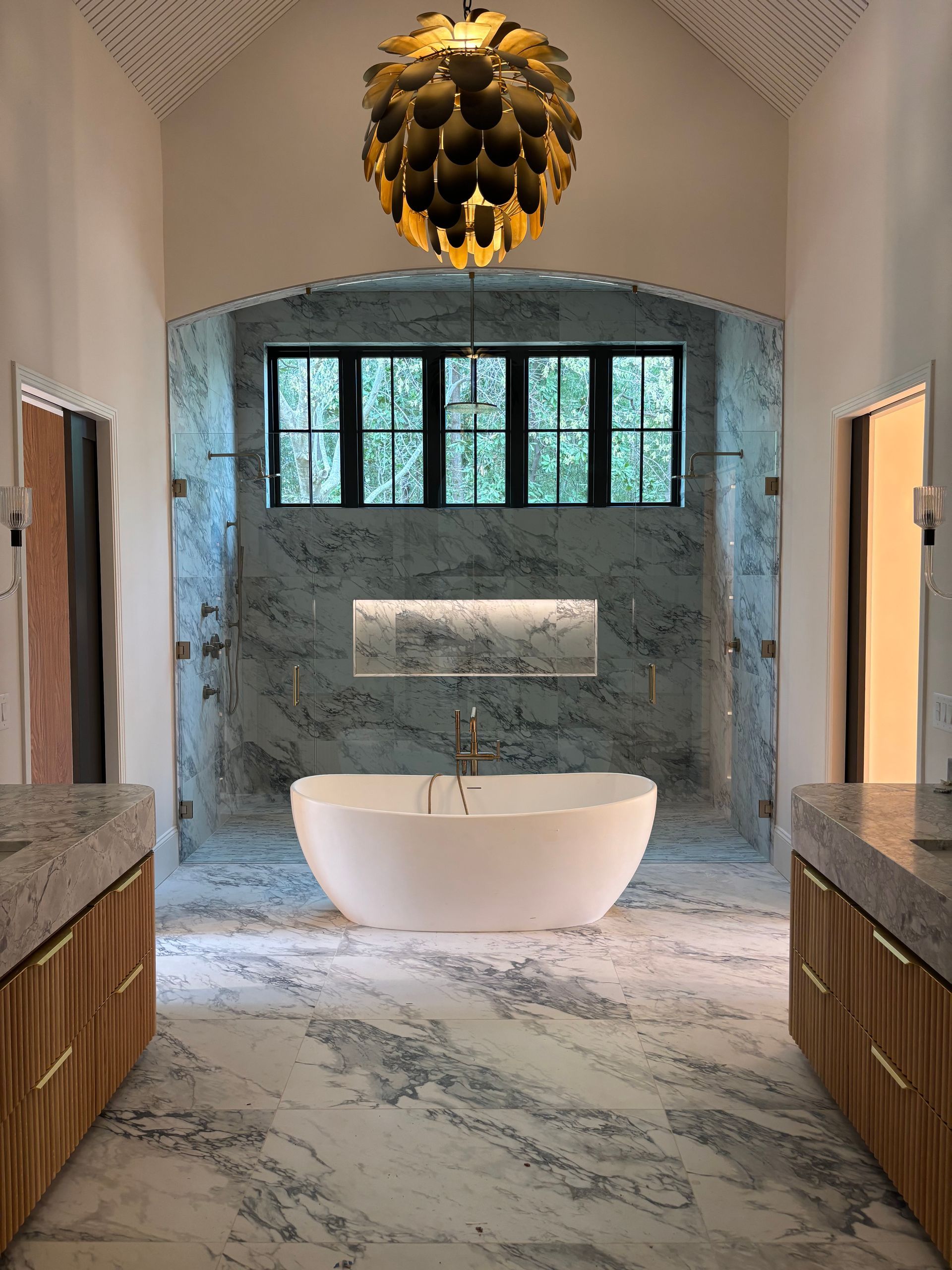 A bathroom with a bathtub and a chandelier hanging from the ceiling.