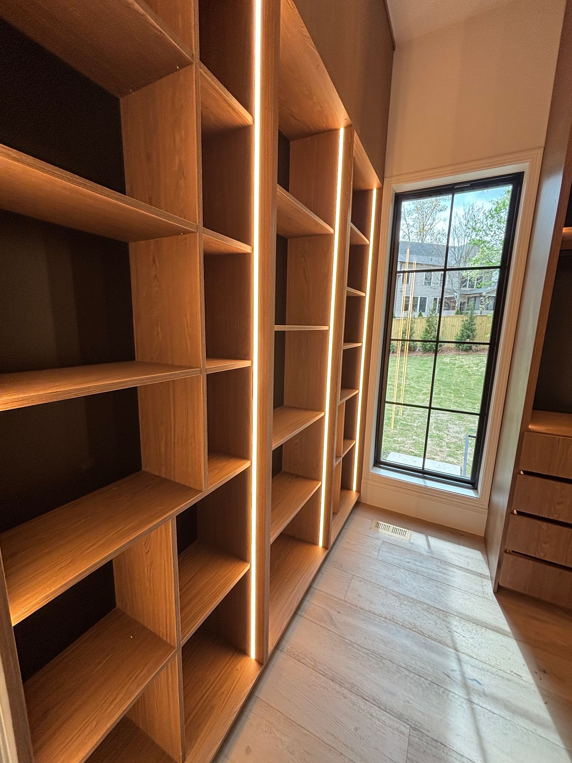 A walk in closet with lots of shelves and a window.