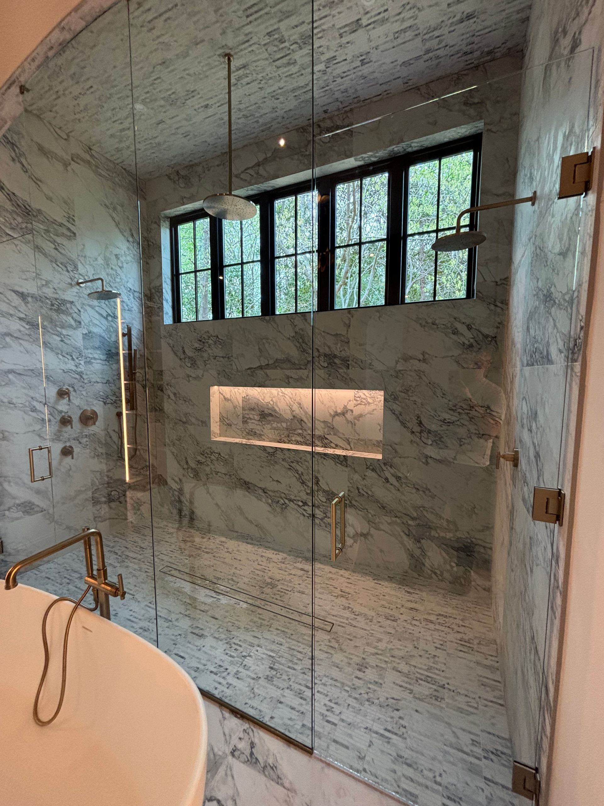 A bathroom with a walk in shower and a bathtub.