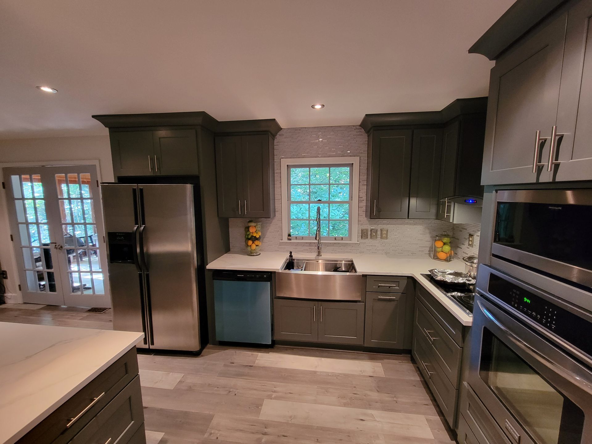 A kitchen with gray cabinets and stainless steel appliances