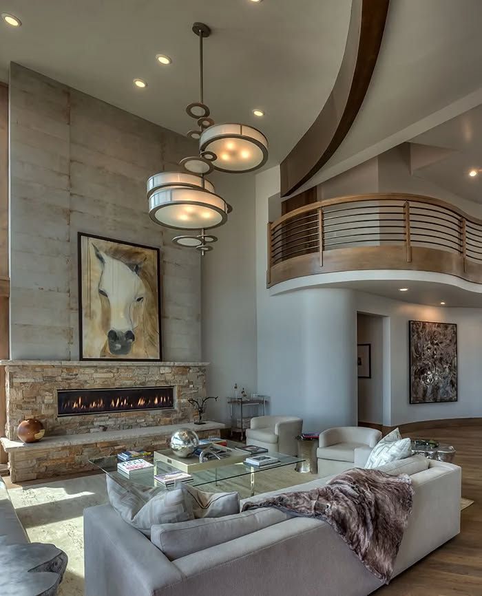 A living room with a fireplace and a picture of a horse on the wall