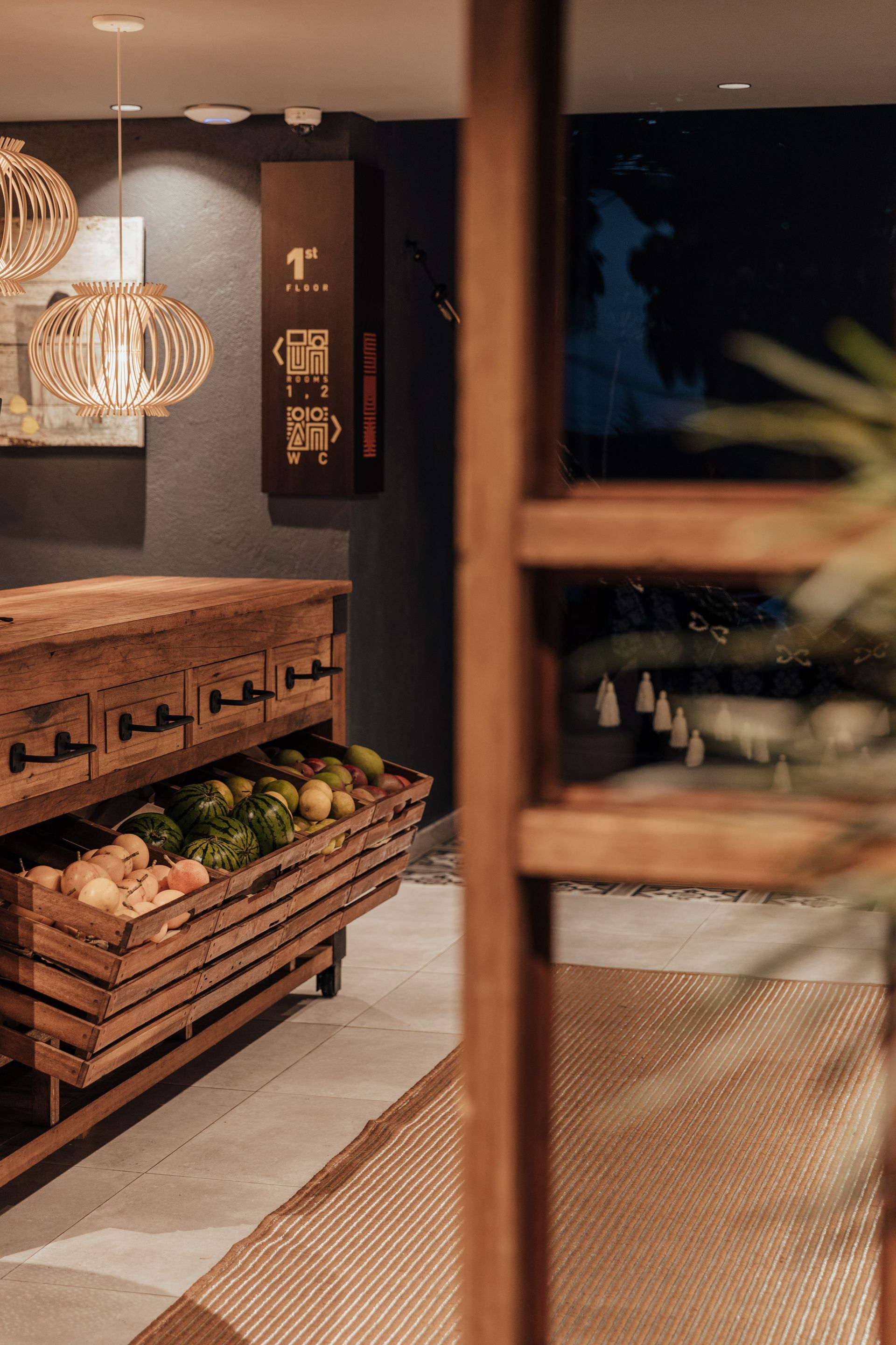 Una caja de madera llena de frutas y verduras en una habitación.
