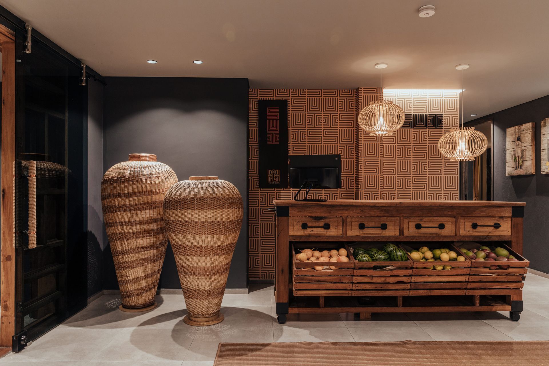 Una cocina con encimera de madera y jarrones de mimbre en el suelo.