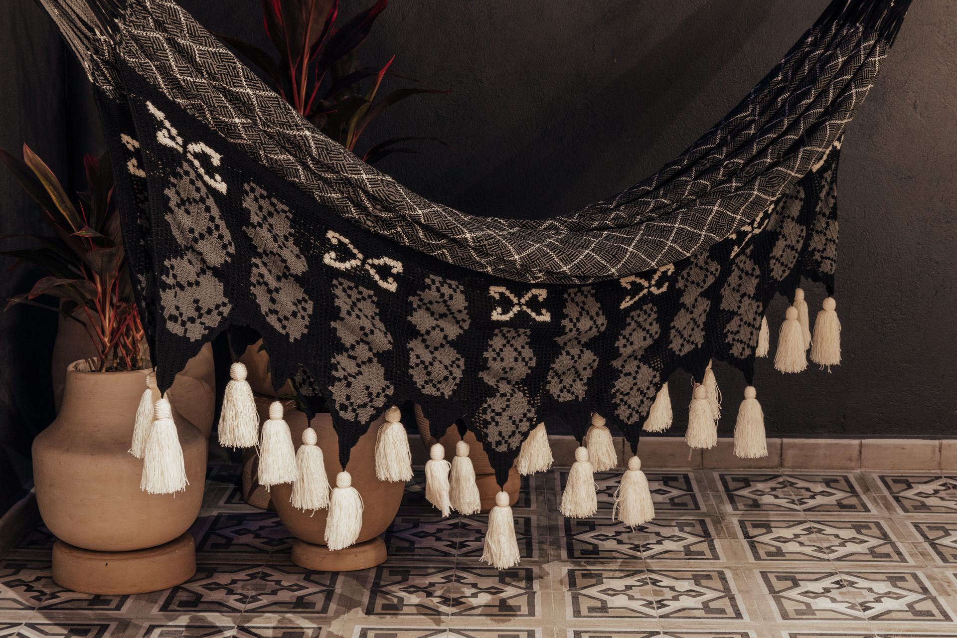 Una hamaca en blanco y negro con borlas colgando de ella.