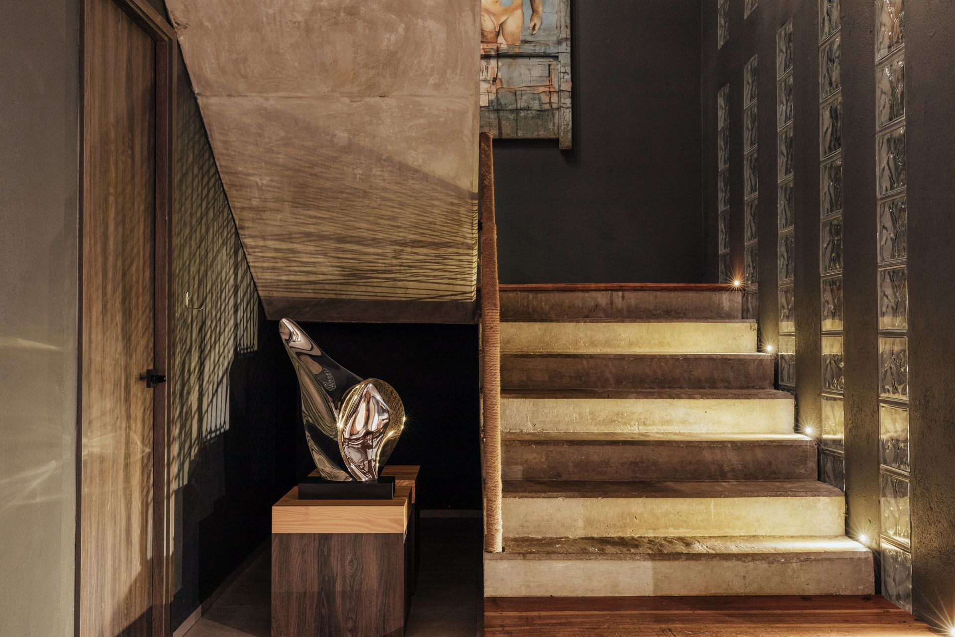 Una escalera con una estatua encima en un pasillo.