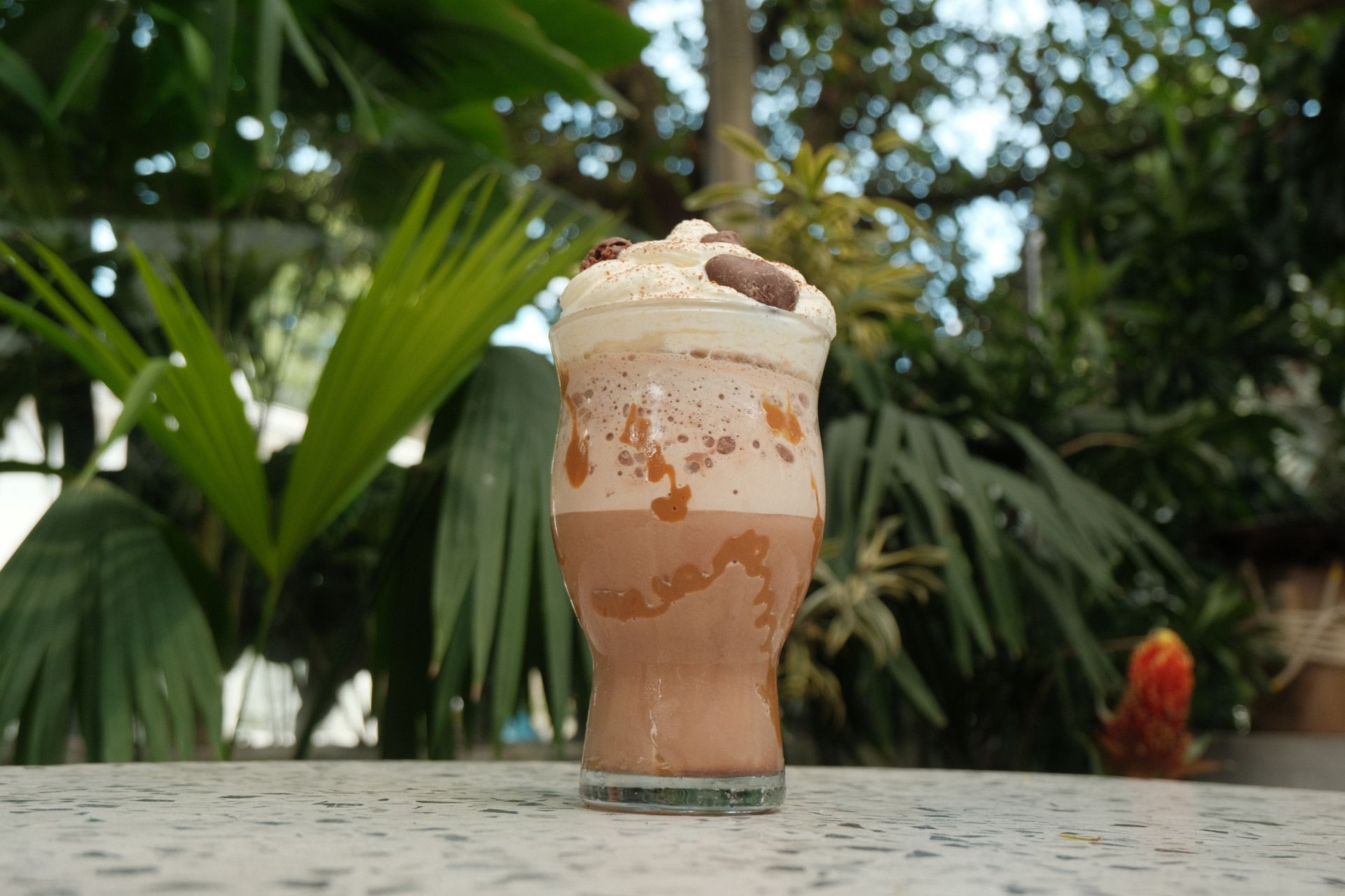 Un primer plano de un vaso de batido de chocolate sobre una mesa.