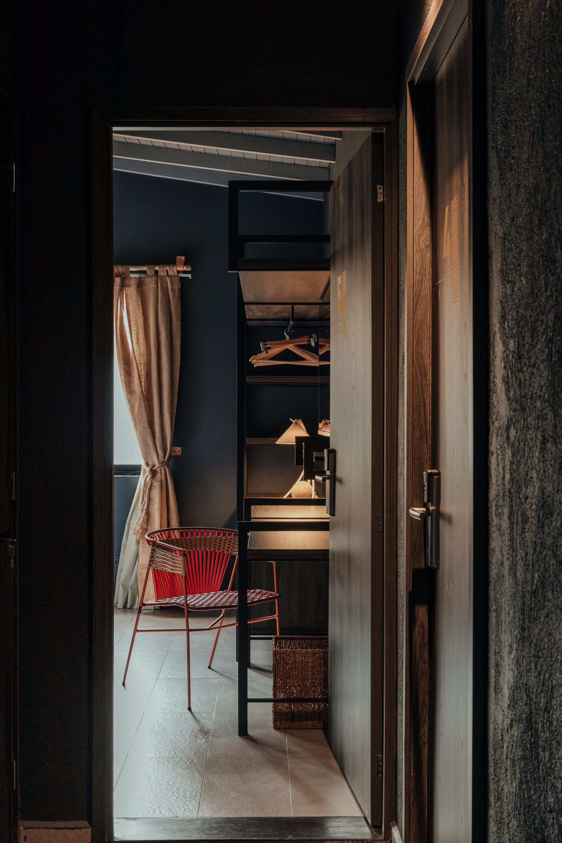 Una puerta que conduce a una habitación con un escritorio y sillas.