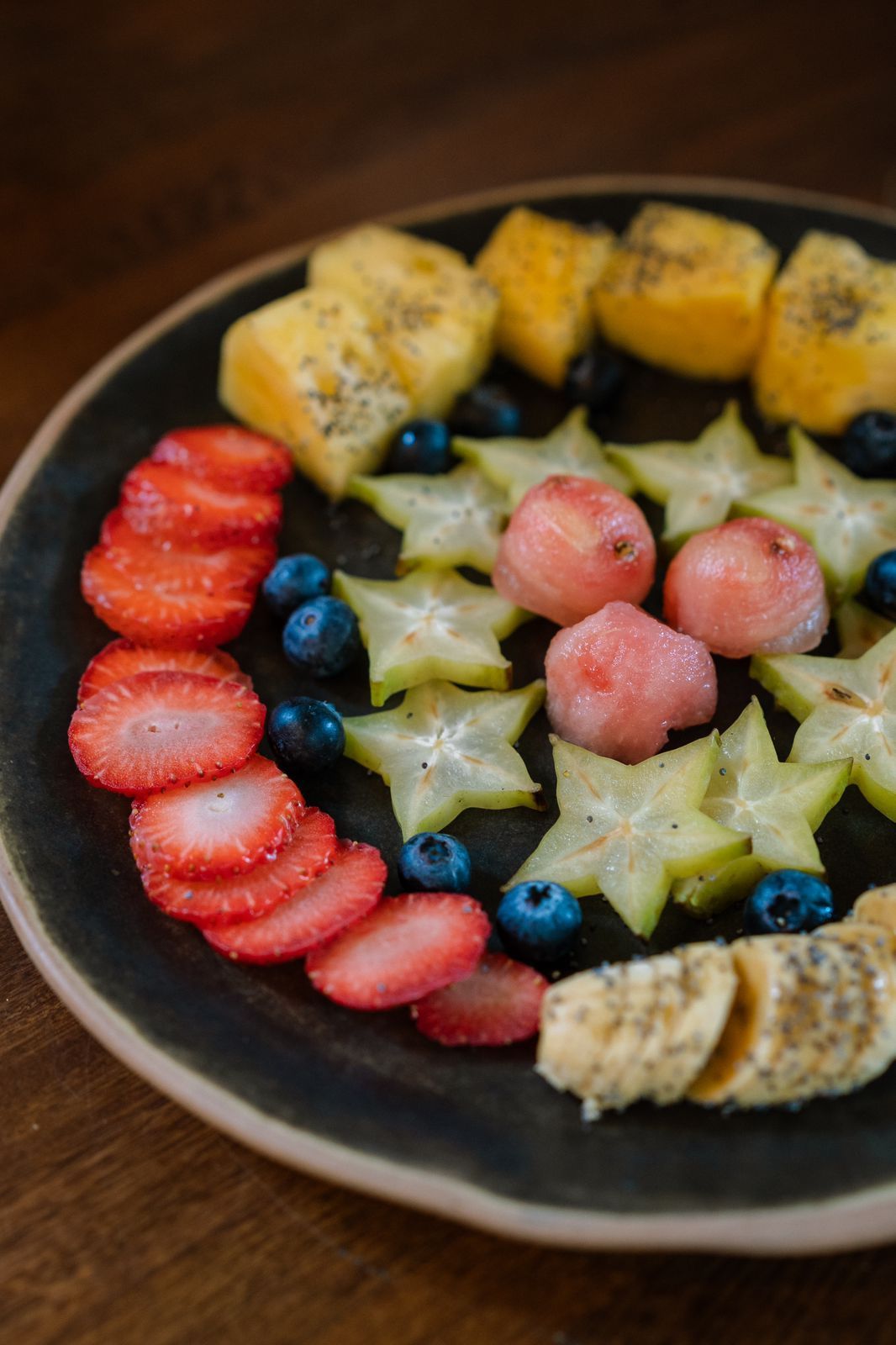 Un primer plano de un plato de fruta en una mesa de madera.