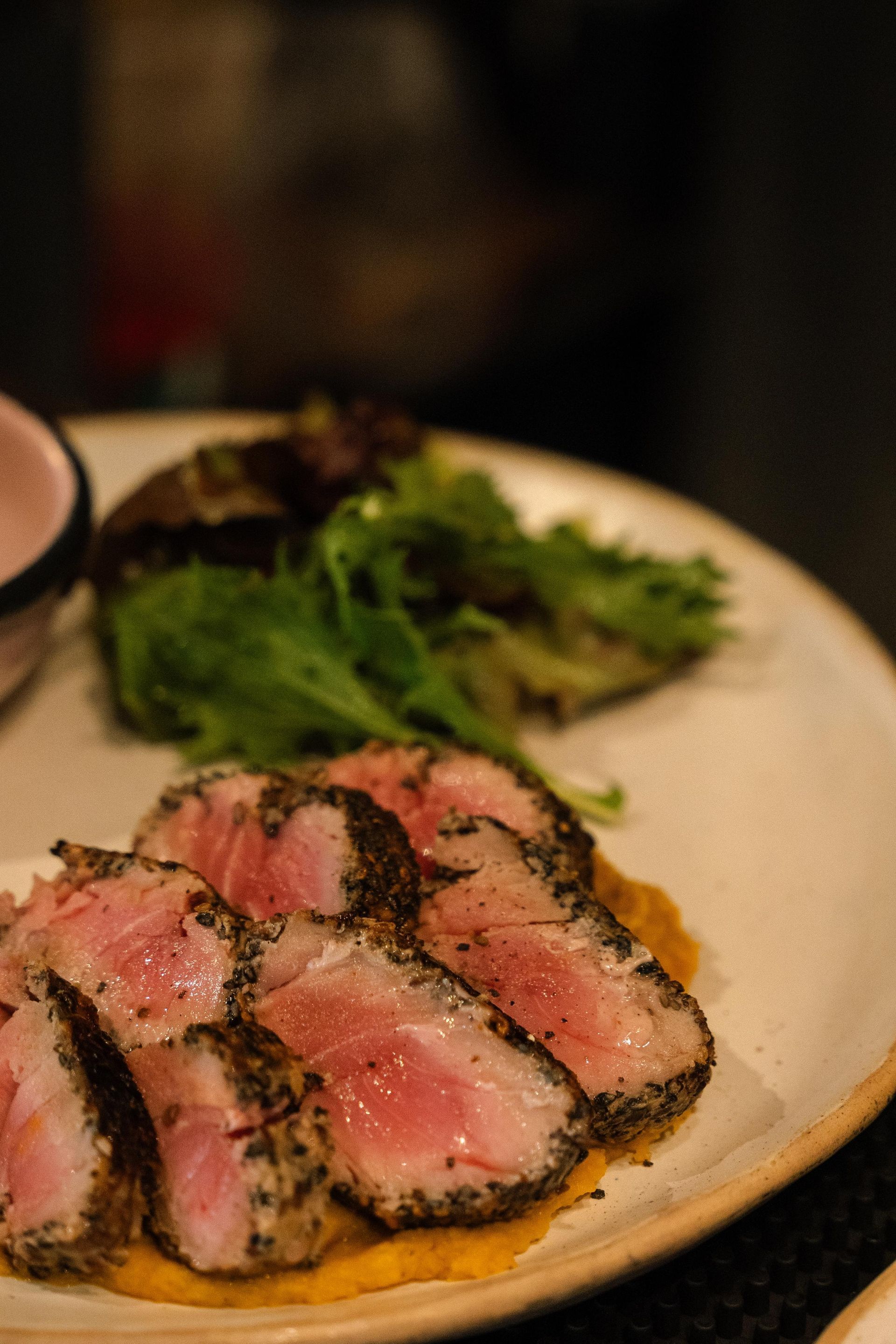 Un primer plano de un plato de comida con carne y verduras sobre una mesa.