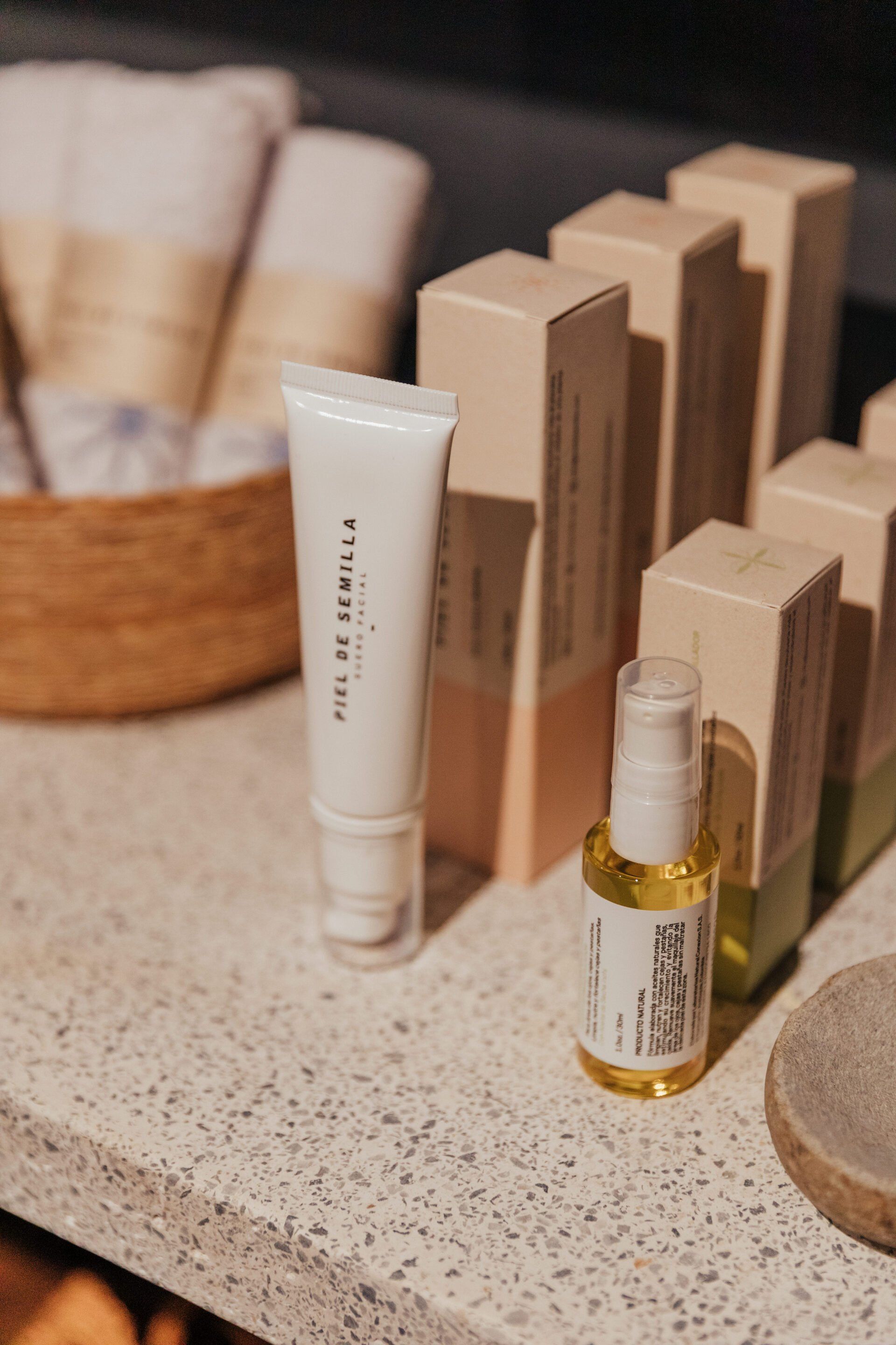 Una botella de aceite está sobre un mostrador al lado de un tubo de crema.