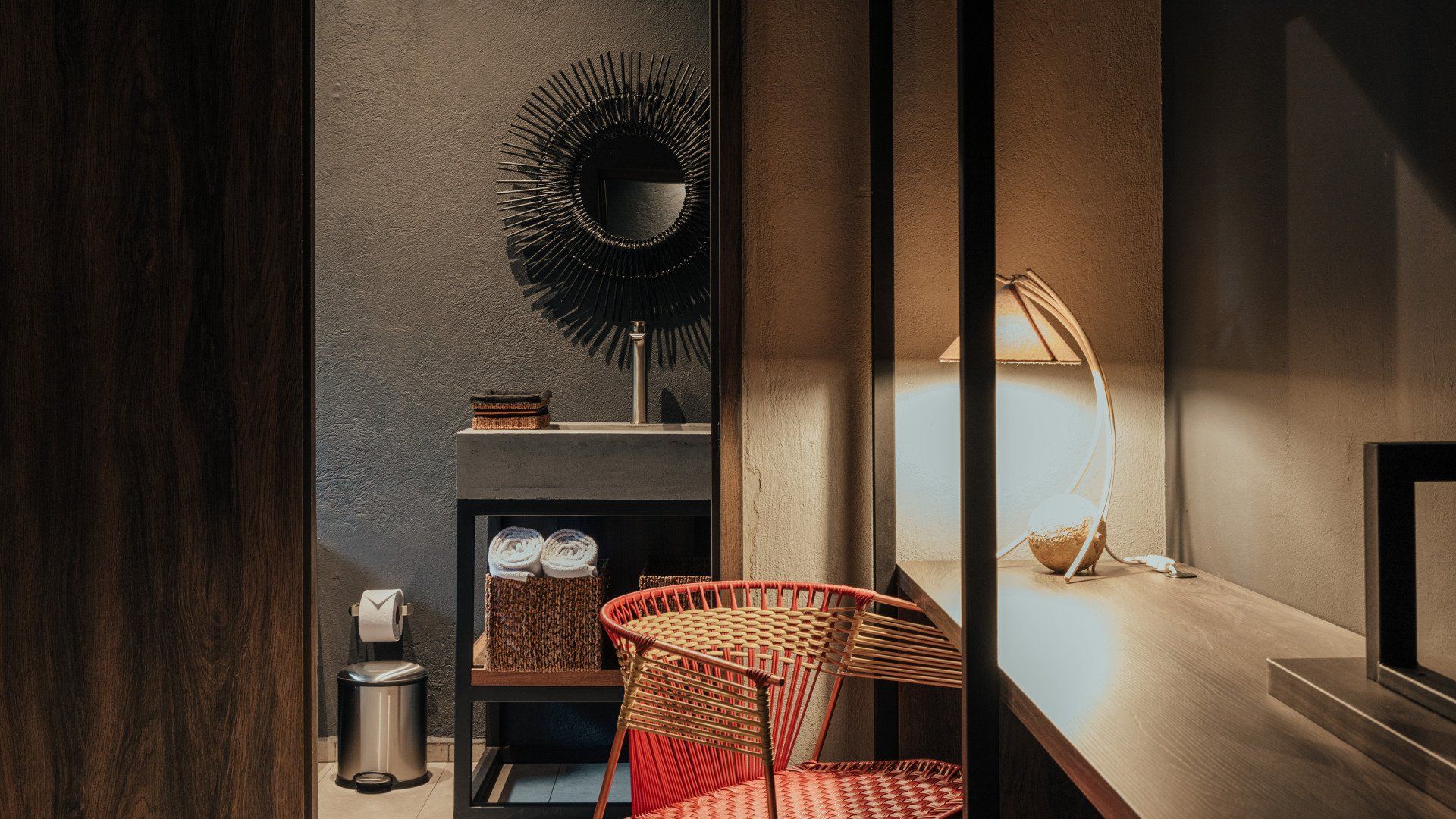 Un baño con lavabo, silla, escritorio y espejo.