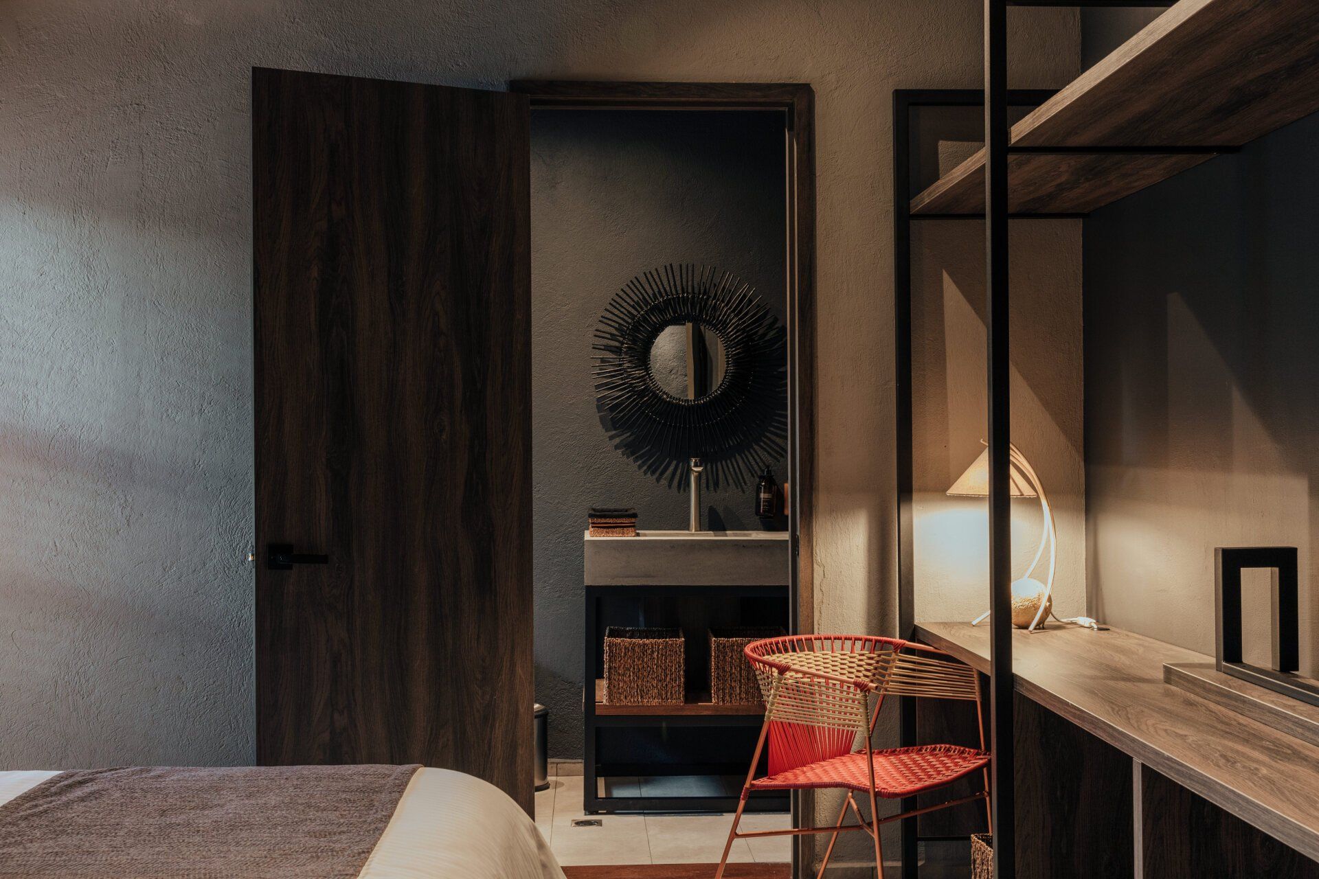 Un dormitorio con una cama, un escritorio y un lavabo.