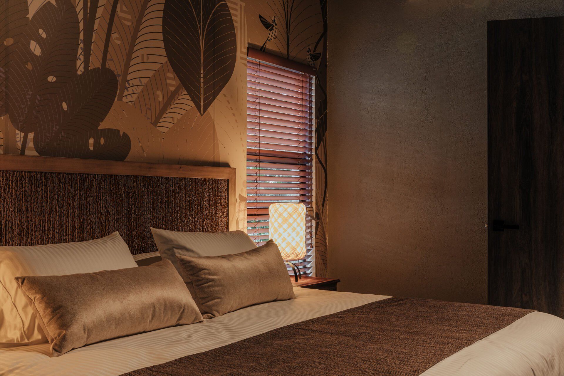 Un dormitorio con una cama y una ventana con persianas.