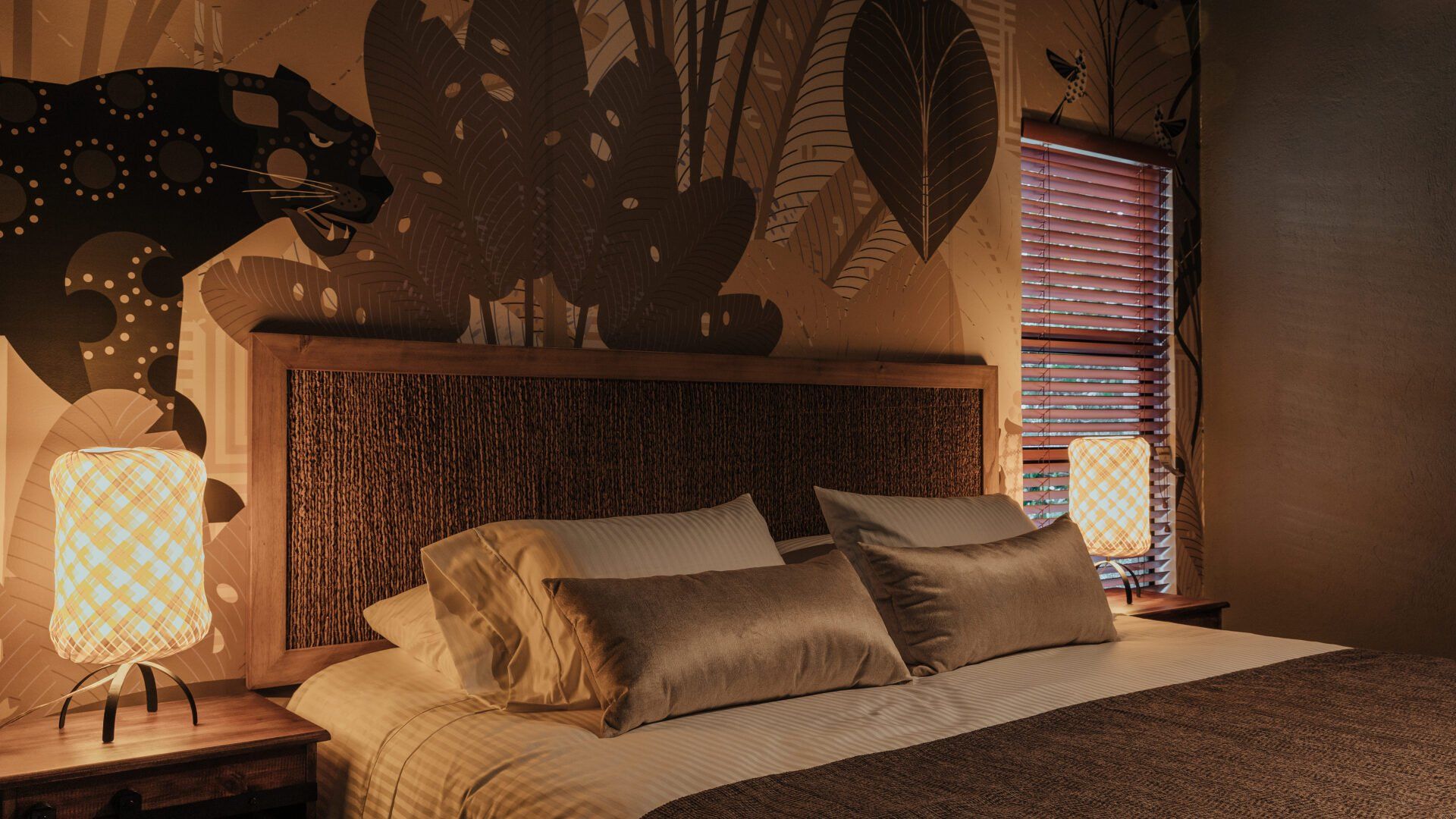 Un dormitorio con una cama y dos lámparas y un cuadro en la pared.