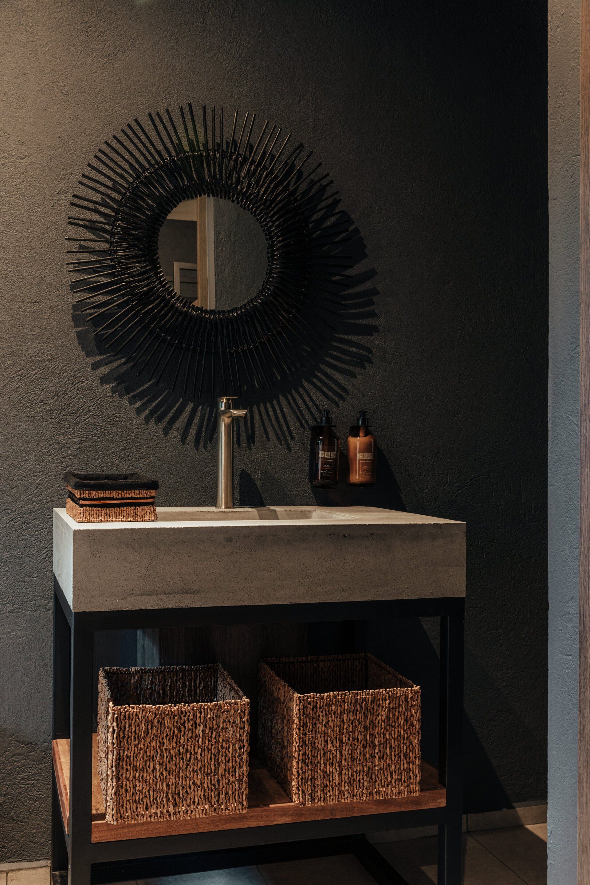 Un baño con lavabo, espejo y cestas.