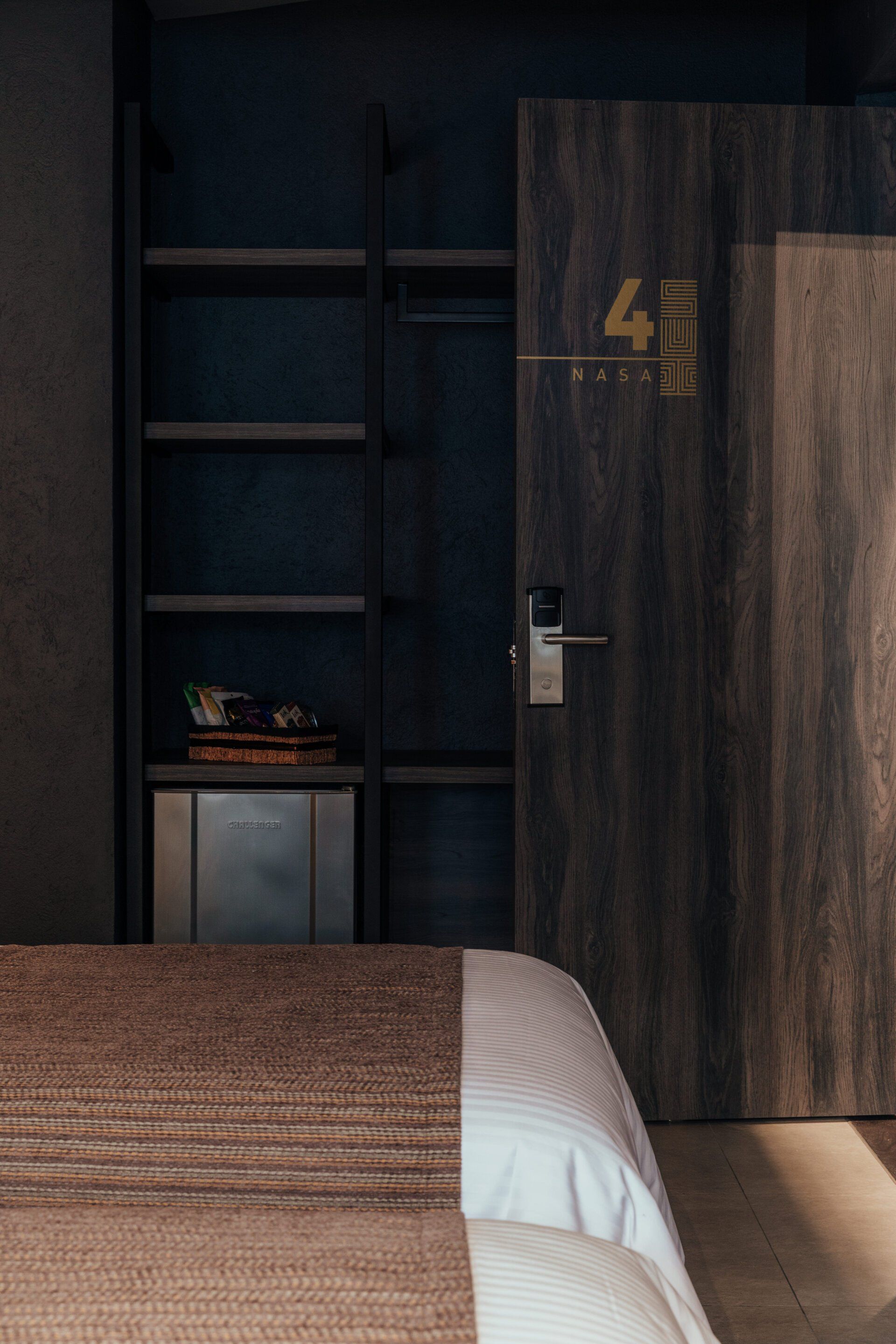 Una habitación de hotel con una cama y una puerta de madera.