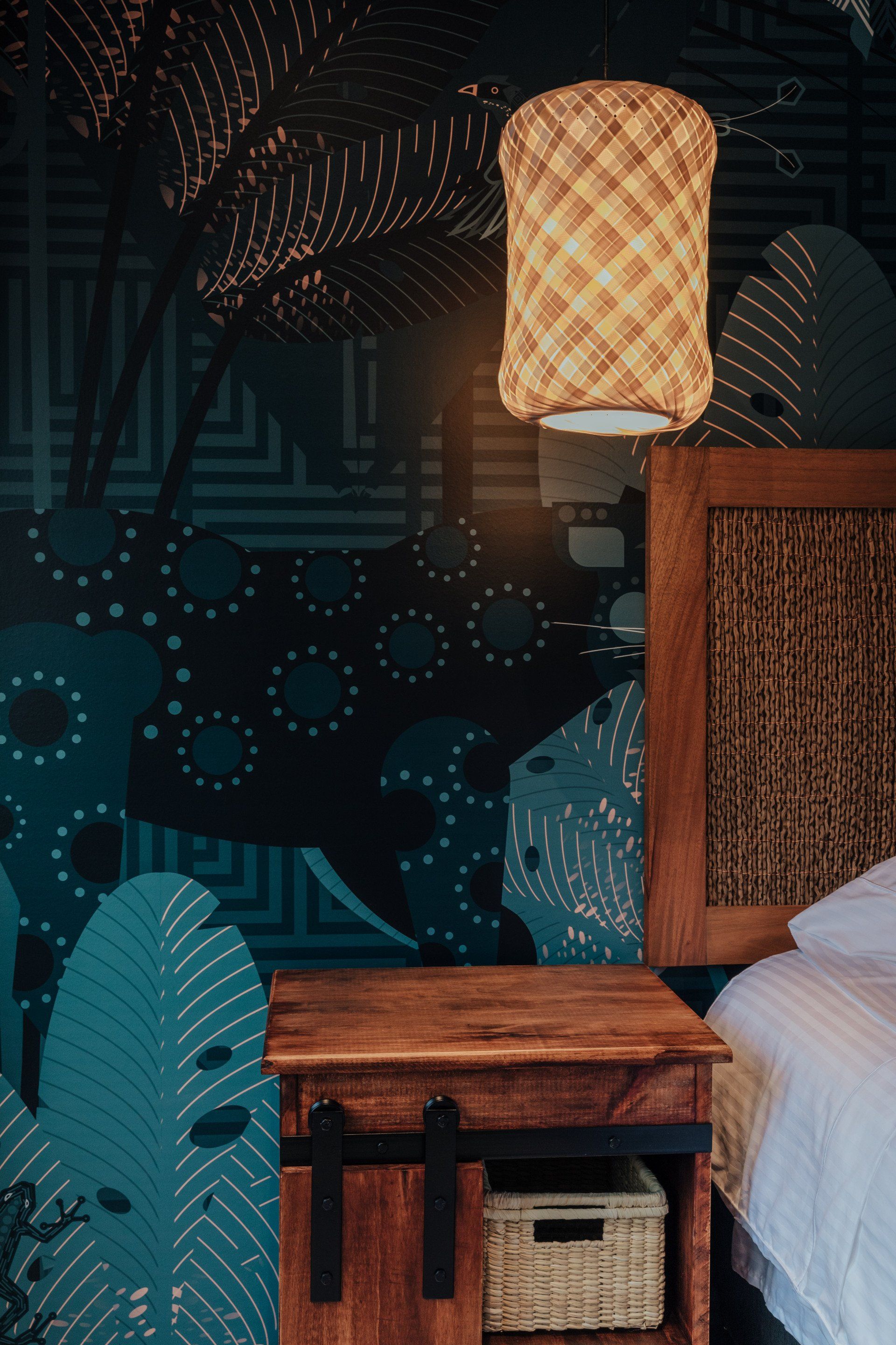 Un dormitorio con una cama, mesita de noche y lámpara.